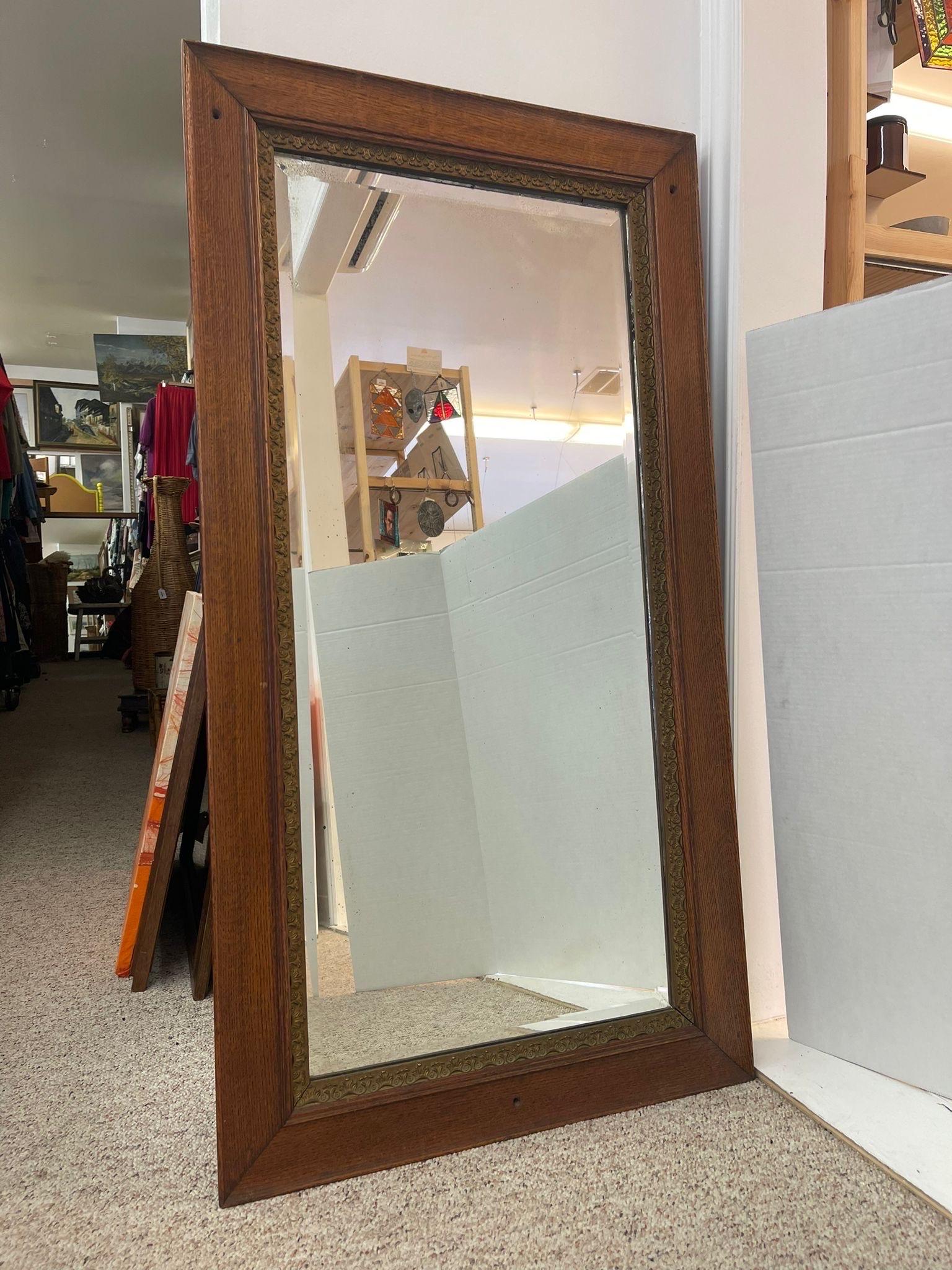 Beveled mirror with wooden frame. The gold toned banding around the frame provides a beautiful accent. Slight Petina to the glass due to age. Vintage Condition Consistent with Age as Pictured.

Dimensions. 25 W ; 1 D ; 48 H