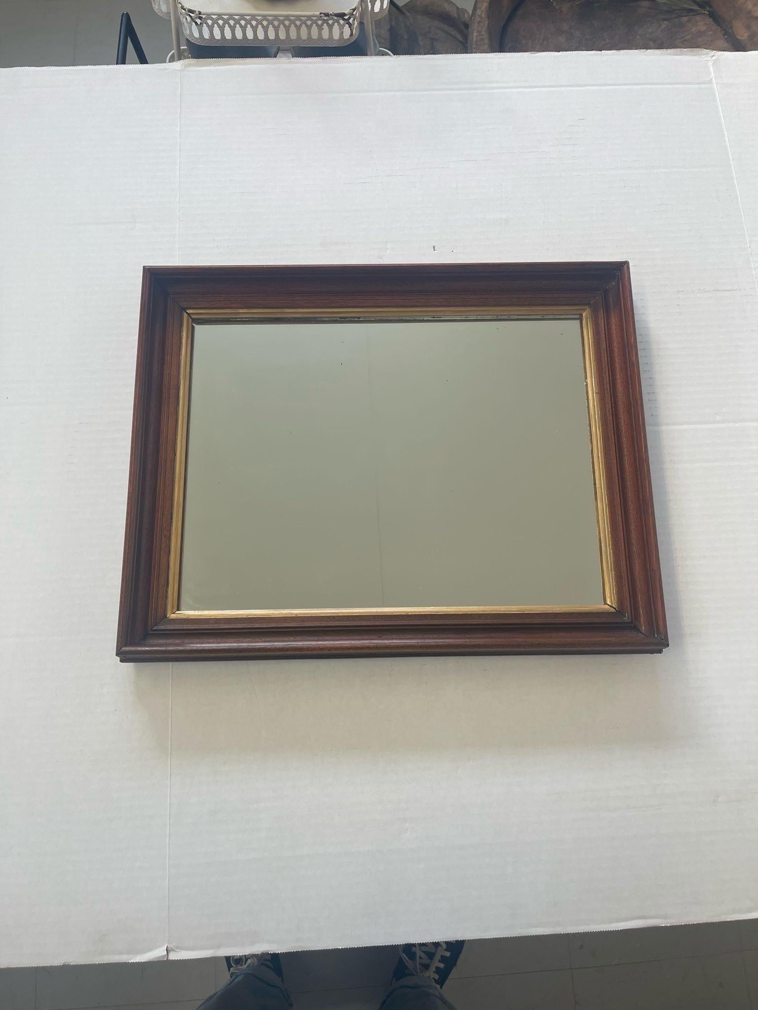 The beveled wood frame on this piece has gold toned accents. Slight Petina to the end of the glass. Vintage Condition Consistent with Age as Pictured.

Dimensions. 15 W ; 1 D ; 21 H