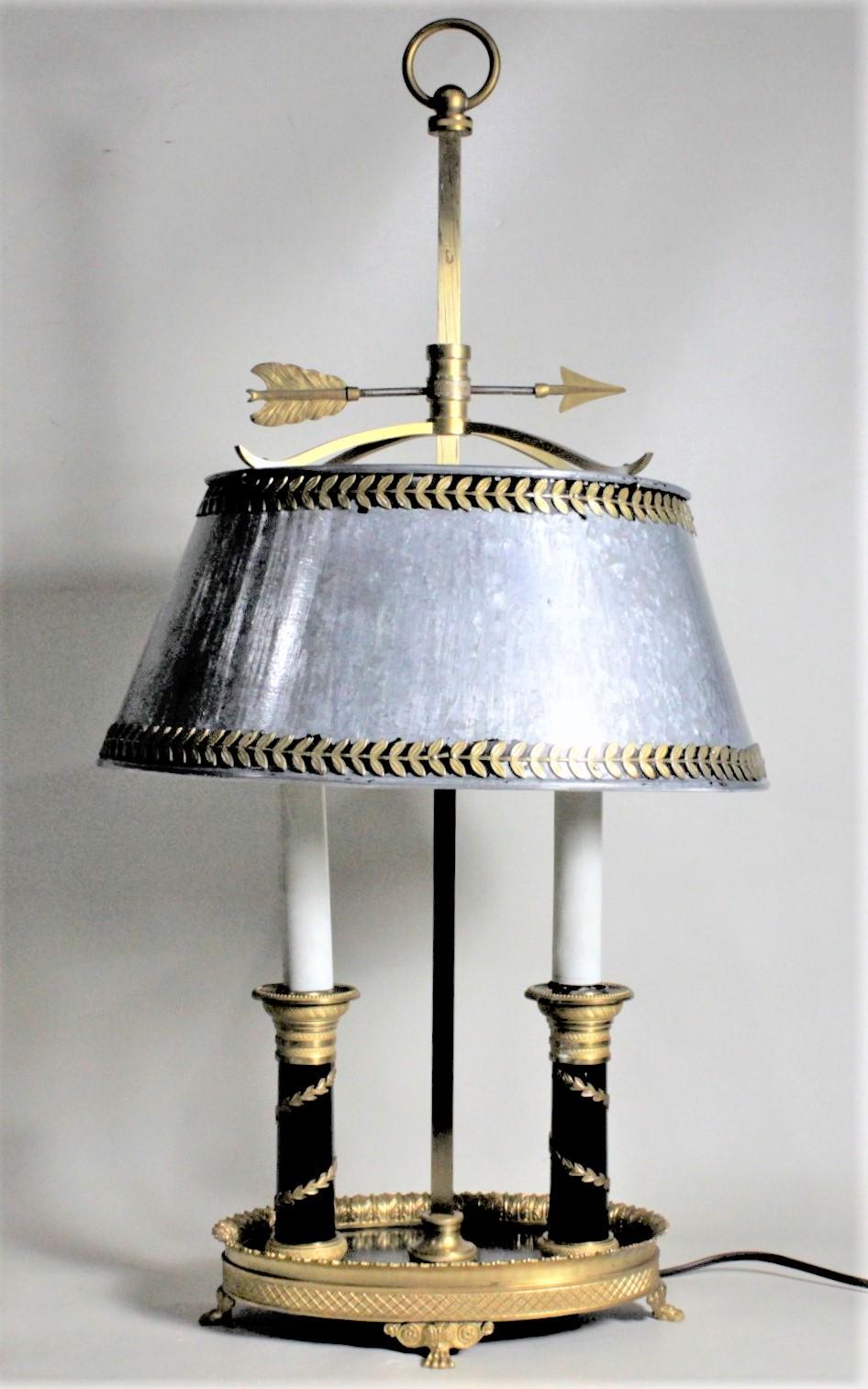 This antique styled toleware table lamp is unsigned, but presumed to have been made in France in circa 1960. The frame of the lamp and shade are cast of solid brass and the painted adjustable shade is cold-painted metal. The cast brass ring finial