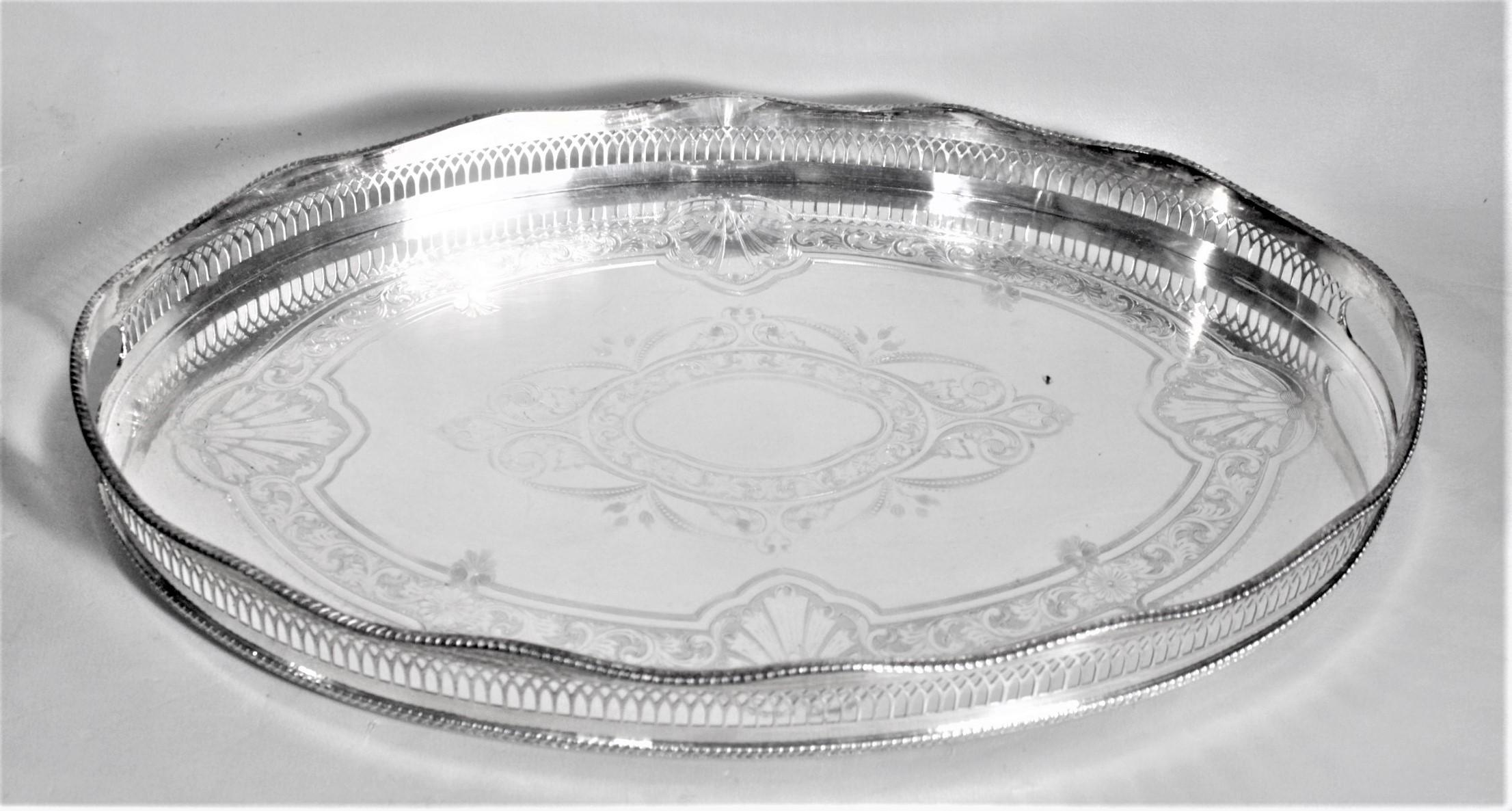 Ce plateau de service ovale en argent plaqué a été fabriqué par Cavendish Plate en Angleterre vers 1950 dans un style ancien. Le plateau est en cuivre argenté et comporte une galerie en relief à chaque extrémité, dans laquelle les poignées ont été