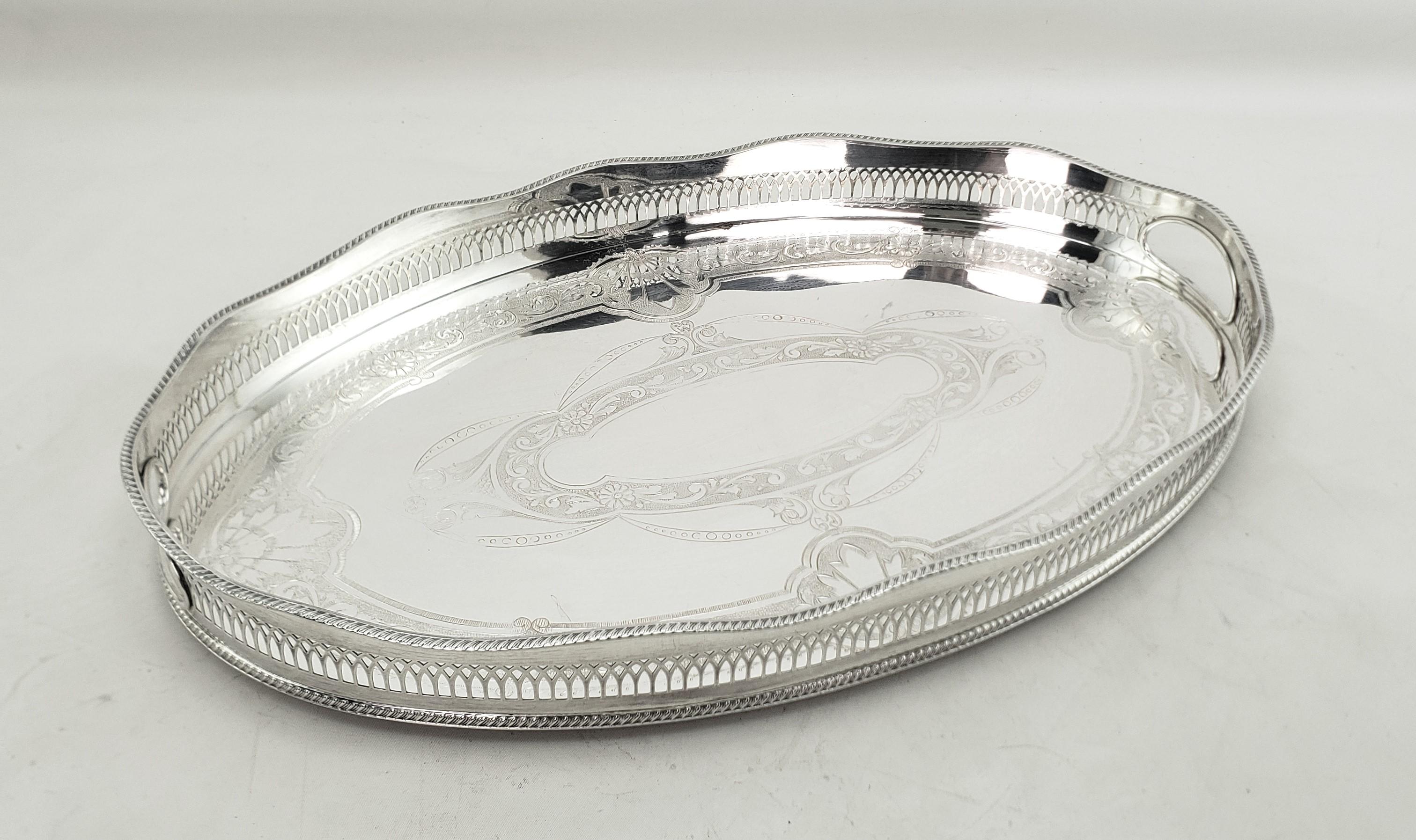 This antique styled serving tray was made by the Cavendish Plating Company of England and dates to approximately 1960 and done in an Edwardian style. The tray is composed of silver plate over copper and has a high pierced gallery with inset handles.
