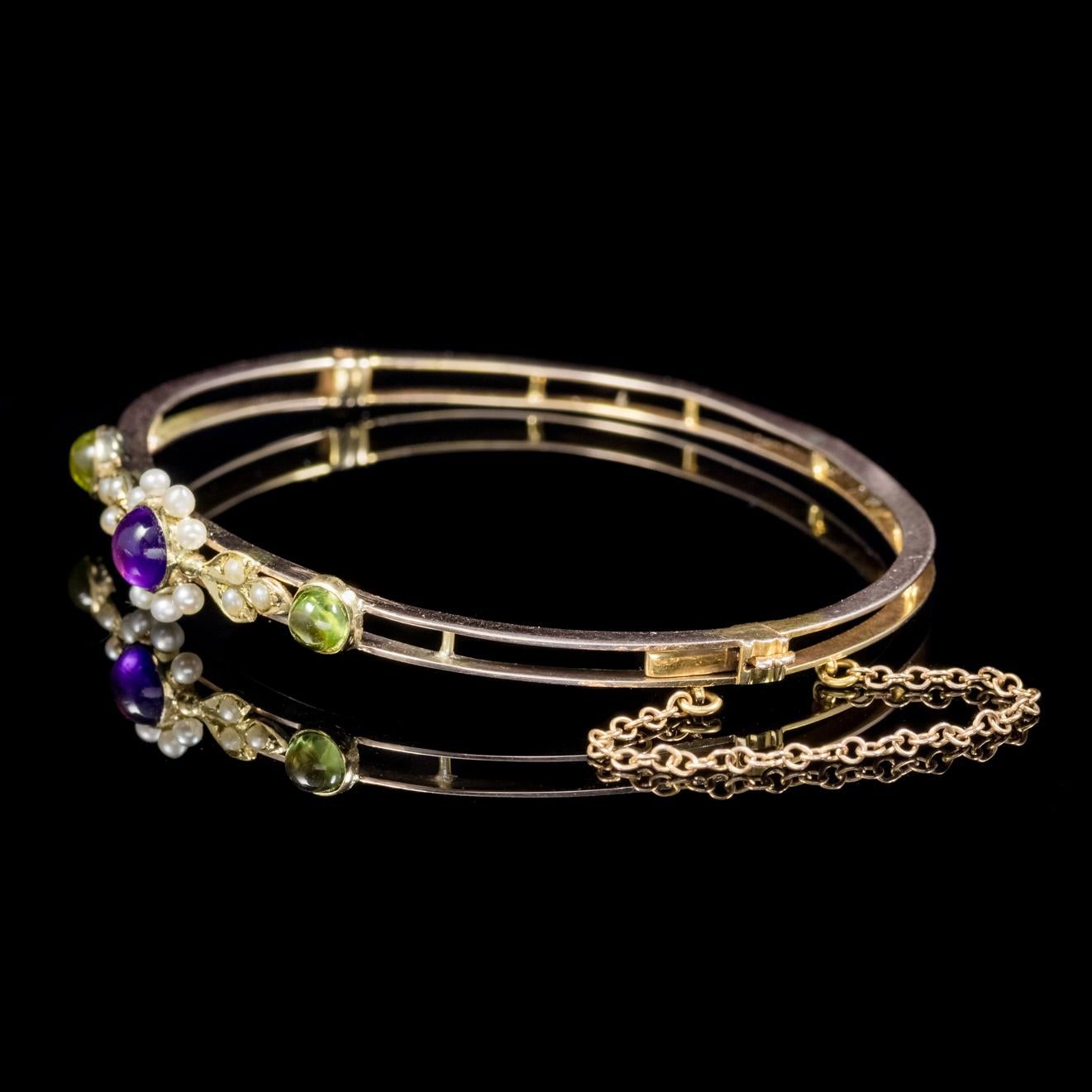 A lovely antique Victorian Suffragette bangle C. 1900, set with a violet 0.50ct cabochon Amethyst, two green 0.22ct cabochon Peridots and fourteen creamy white Pearls. 

Suffragettes liked to be depicted as feminine, their jewellery popularly