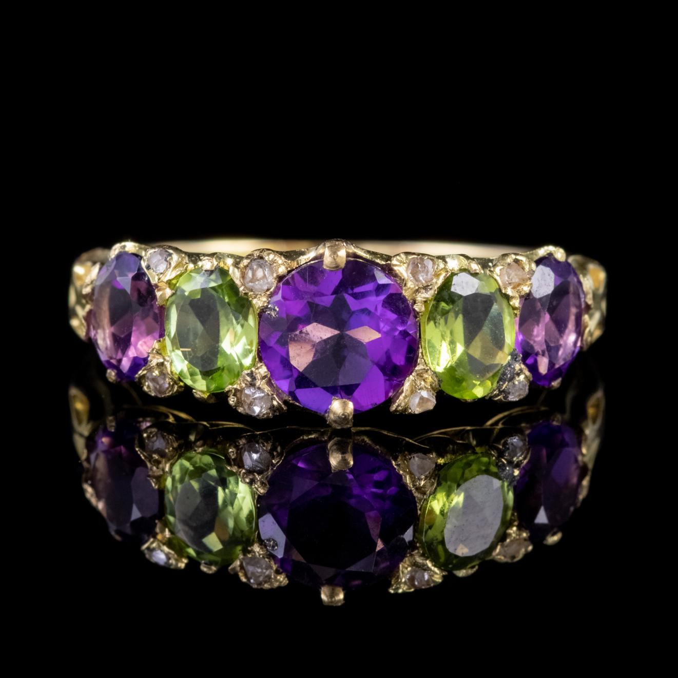 A beautiful Antique Edwardian Suffragette ring adorned with a deep violet Amethyst in the centre which is approx. 0.95ct and flanked by smaller 0.50ct Peridots and Amethysts with twinkling Diamonds nestled in-between.   

Suffragette jewellery was