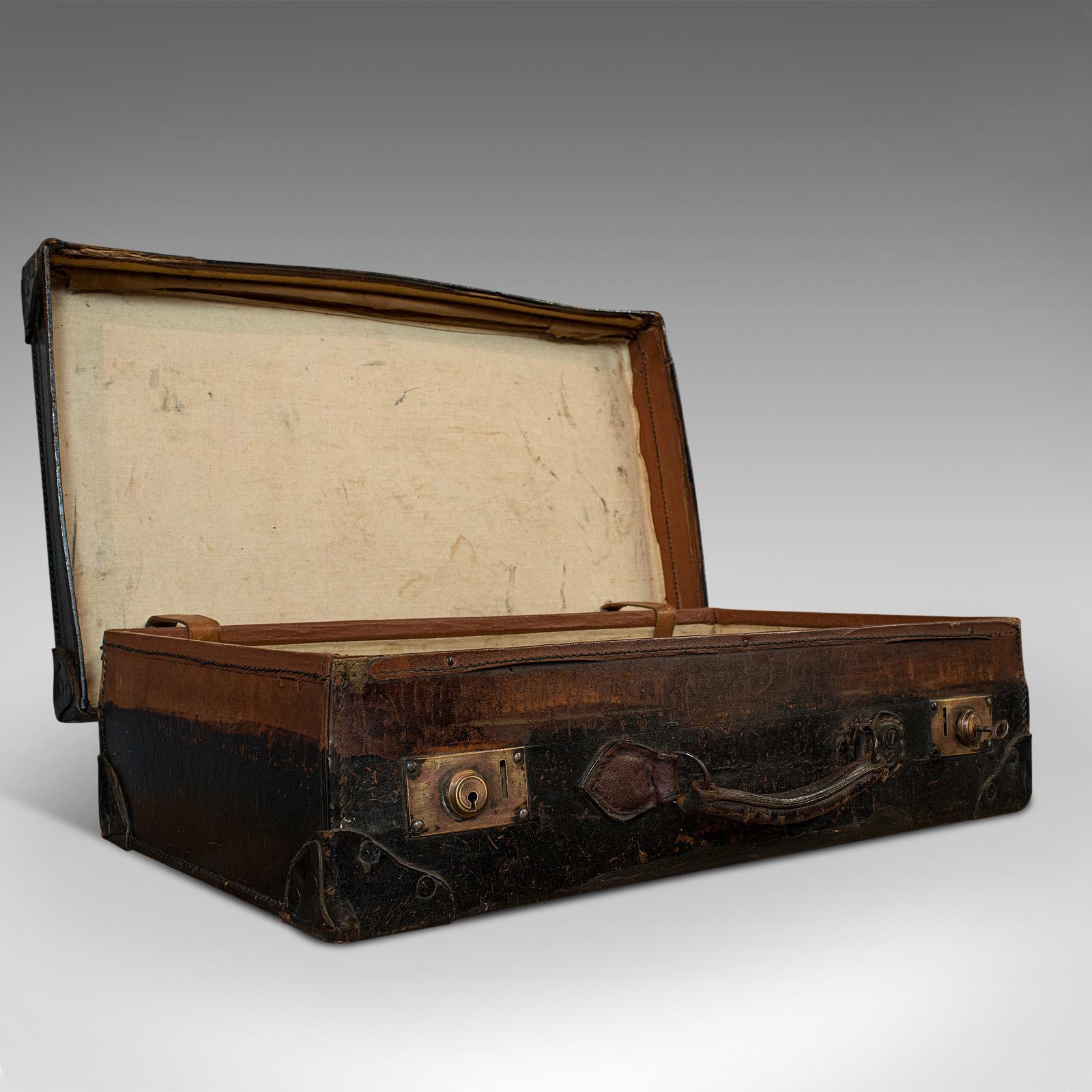 This is an antique suitcase. An English, leather travelling salesman's or officer's case, dating to the Edwardian period, circa 1910.

Generously sized antique case
Displays a desirable aged patina
Leather shows deep black hues
Stitched seams