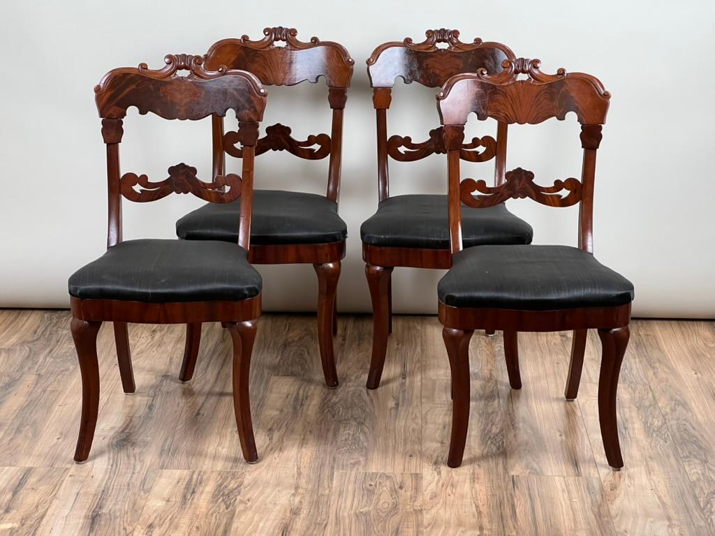 Este hermoso conjunto de cuatro sillas laterales de pata de sable data de alrededor de 1840 y refleja la refinada elegancia del periodo Imperio Americano. Cada silla presenta chapas de caoba flameada bellamente figuradas, hábilmente aplicadas para