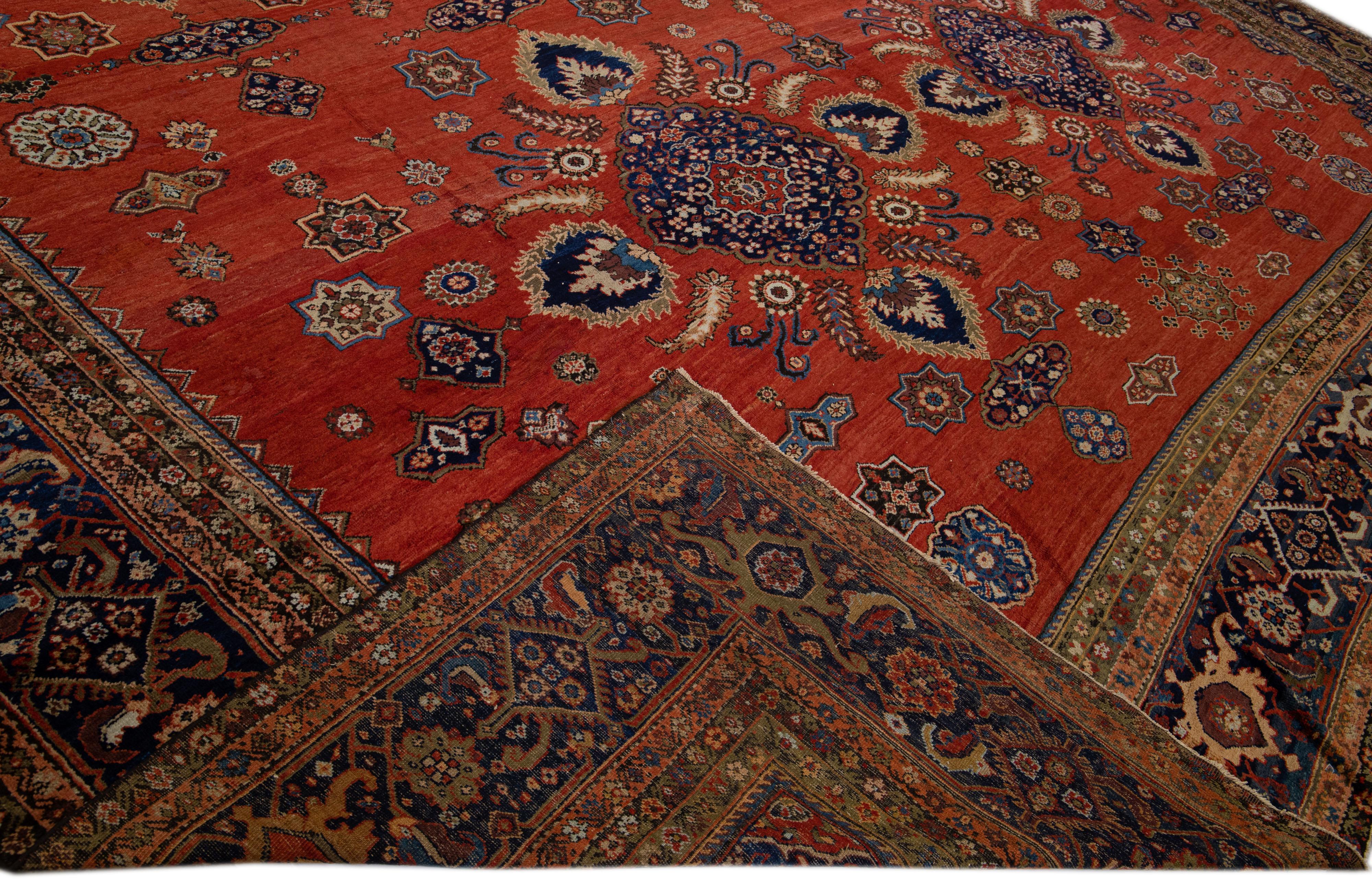 Beautiful antique Persian Sultanabad hand-knotted wool rug with a red field. This piece has a navy blue color-designed frame with multicolor accents in a gorgeous all-over floral pattern design.

This rug measures: 18'6