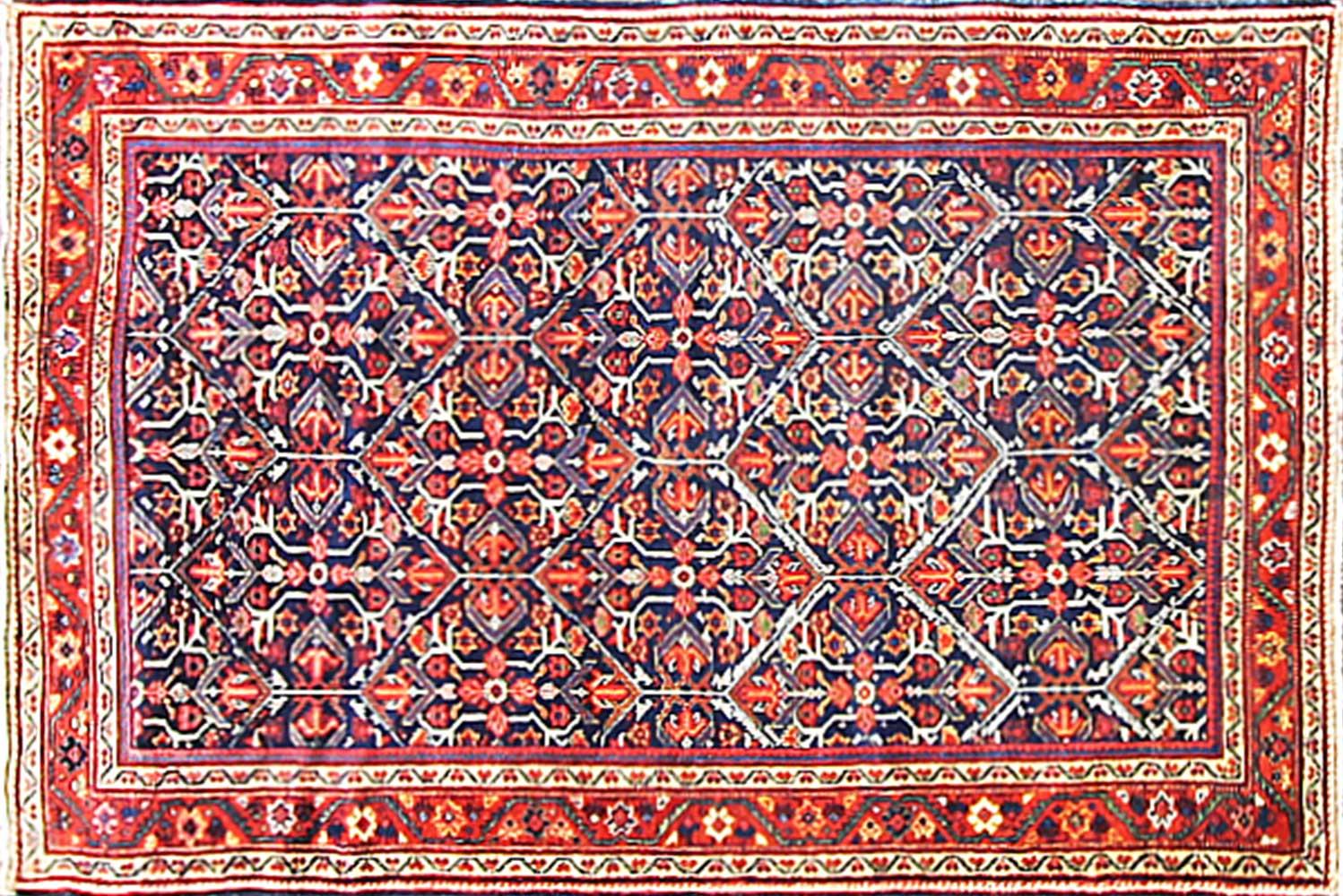 Vintage handwoven vegetable-dyed wool Persian Sultanabad rug. Features an allover geometric floral pattern in ivory and red on a blue field. Measures: 4'7