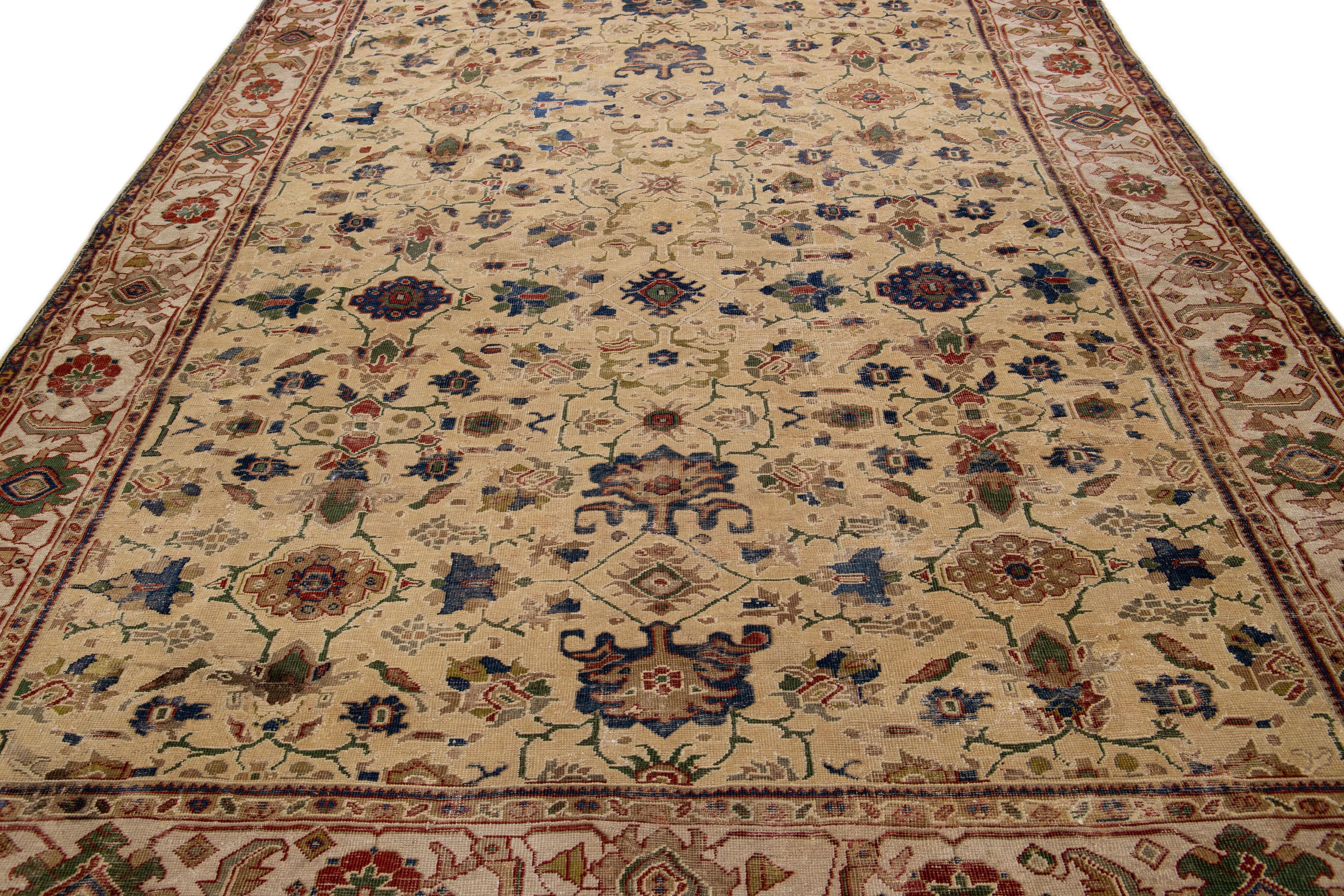 Beautiful antique Persian Sultanabad hand-knotted wool rug with a tan field. This piece has a beige-designed frame with red, blue, and green accents in a gorgeous all-over floral design.

This rug measures: 8'3