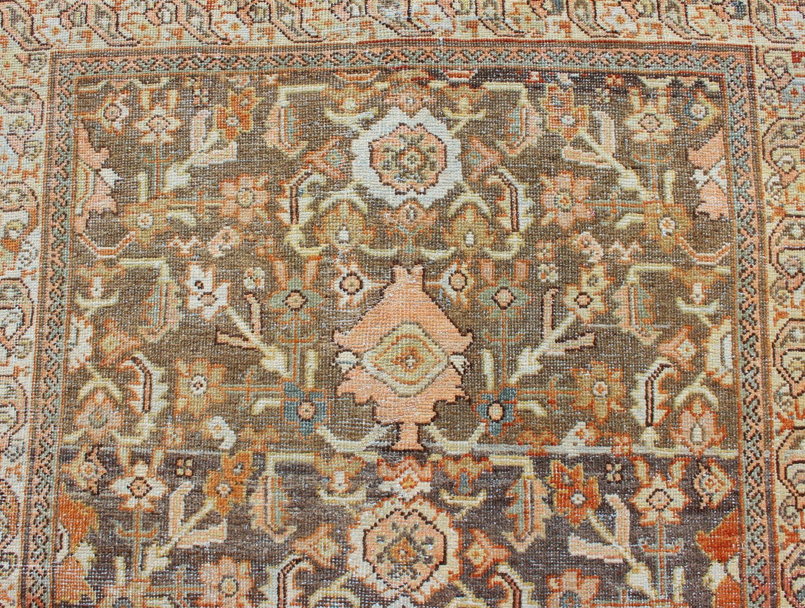 Early 20th Century Antique Sultanabad with Muted Background and Hints of Red and Orange For Sale