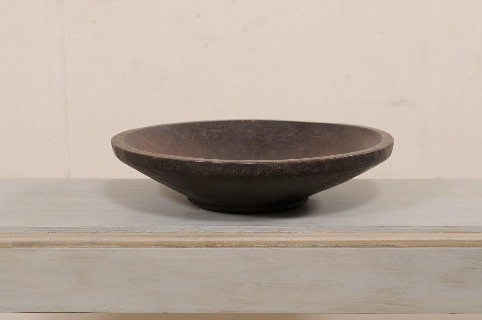 Un bol en bois sculpté à la main de Sumatra datant du début du 20e siècle. Ce bol en bois ancien provient de la province de Lampung à Sumatra, située à l'extrémité sud de l'île. Ce magnifique bol en bois a été sculpté à la main à partir d'une seule