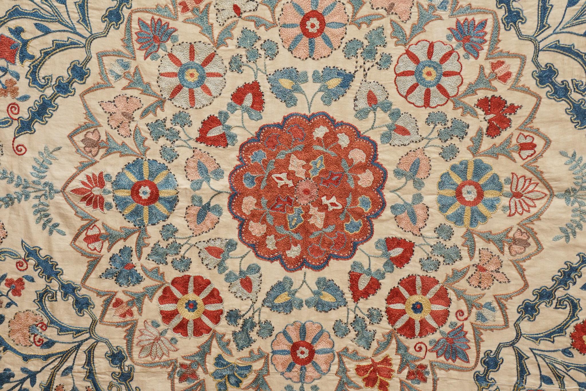 Originating from nomadic tribes in Tajikistan, Uzbekistan, and Kazakhstan, Suzanis, like the one shown here, are known for their intricate embroidery, rich coloration and elaborate design motifs.  This Suzani, possibly late 18th / early 19th