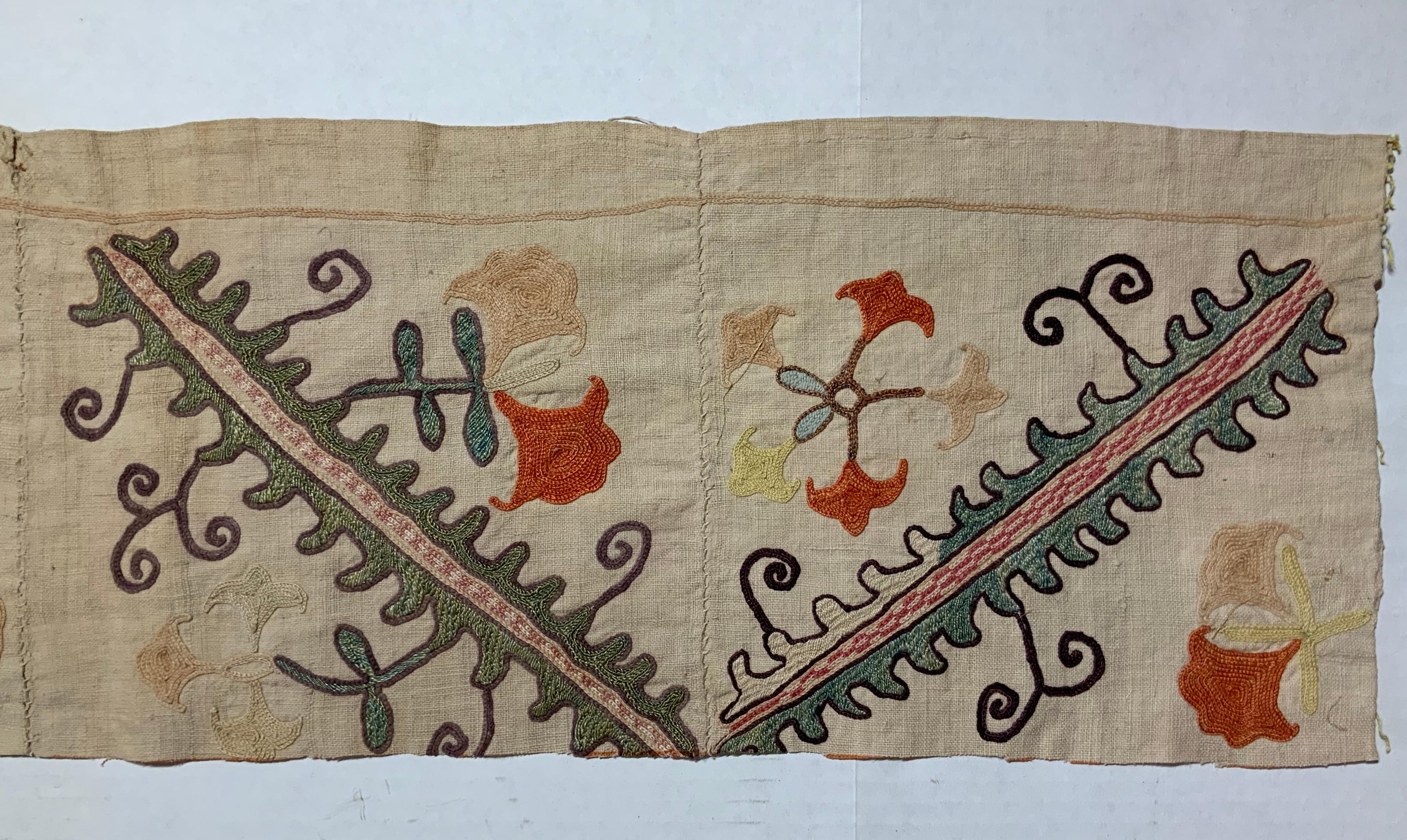 Antique Suzani fragment made of hand embroidery intricate scrolling vines and flowers motifs on a handwoven cotton background.
This piece has some spots and fading areas, some small tears, some oxidization due to age but still has a good structural