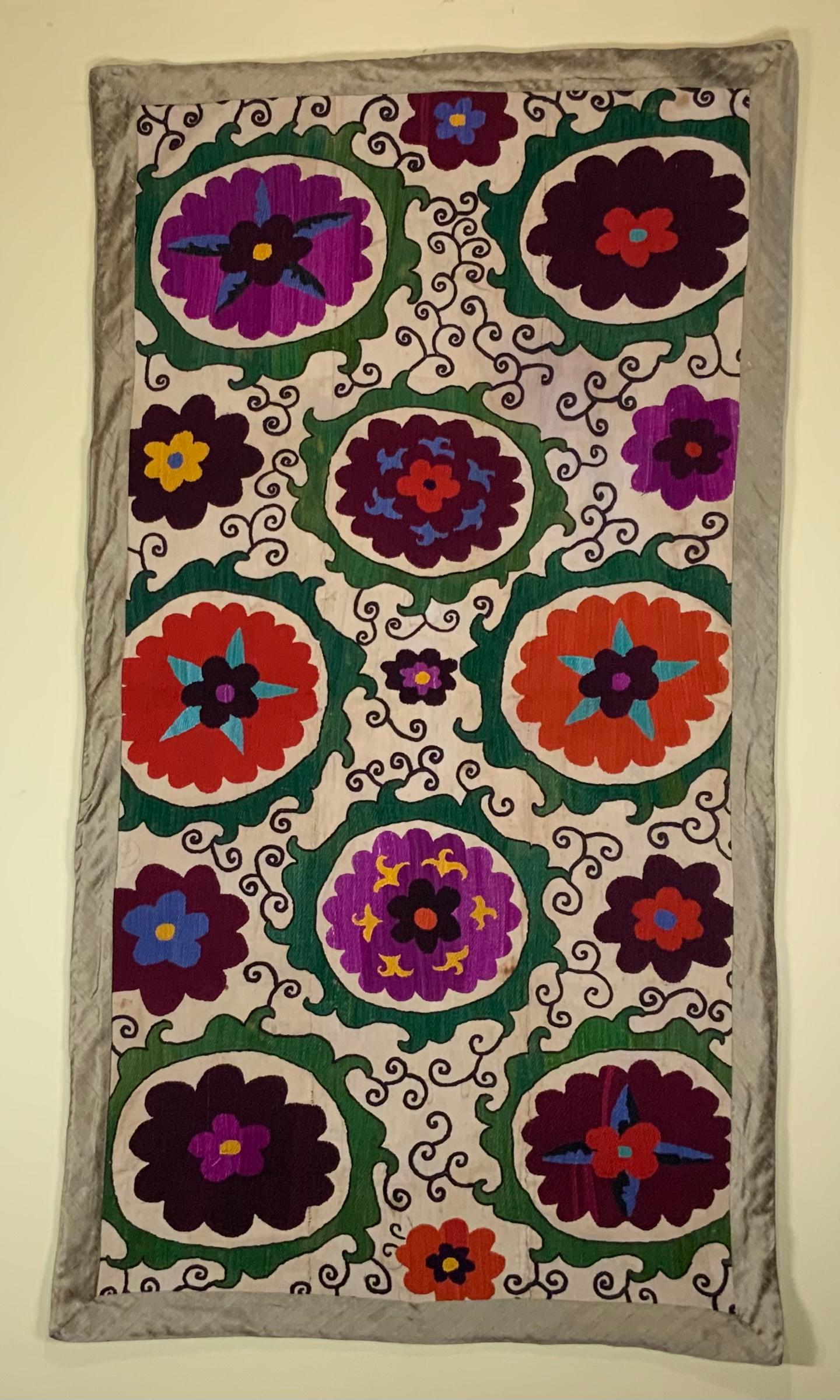 Antique Suzani textile made of hand embroidery intricate scrolling of eight large flowers motifs on a handwoven cotton background. Professionally cleaned and backed with fine textile.
Could use as wall hanging or on top of table or