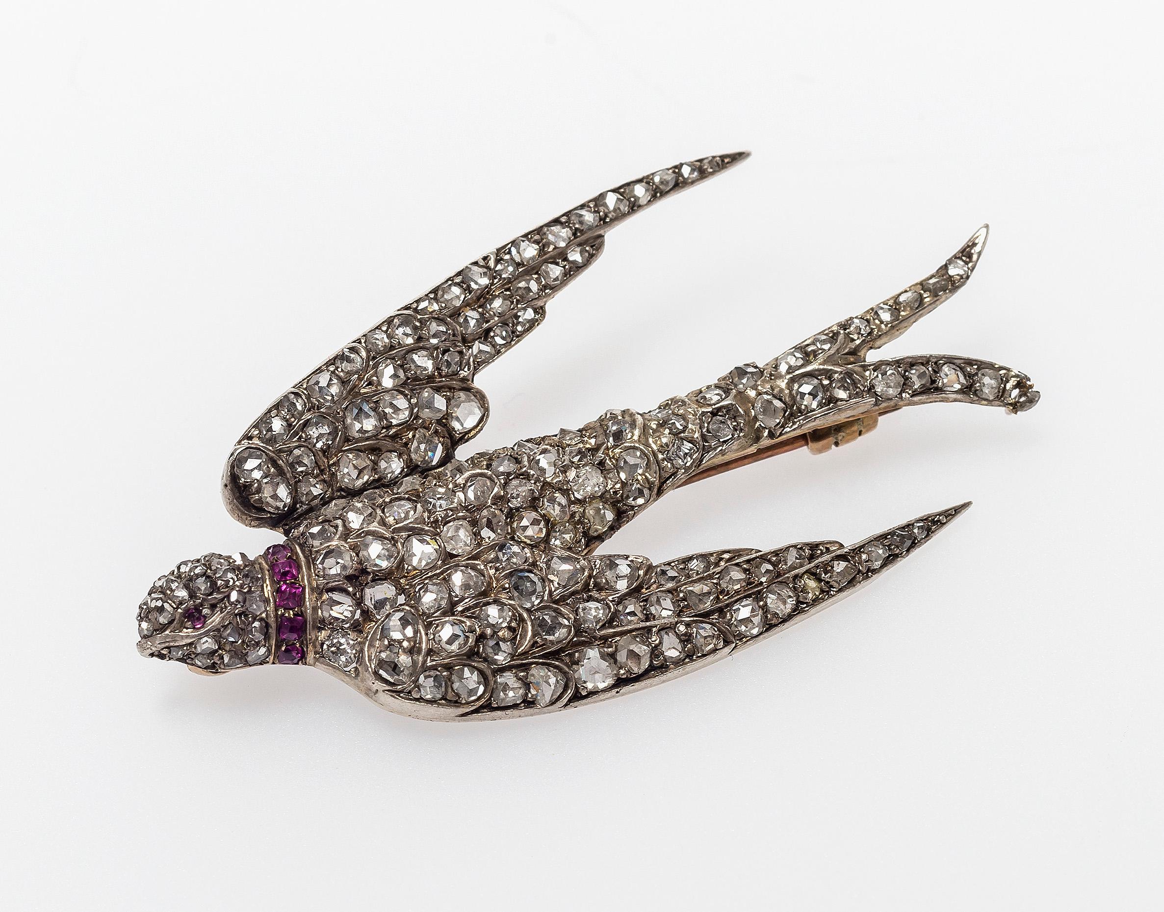 Diese elegante, tauchende Diamantschwalbe trägt ein rot emailliertes Band um ihren Hals. Sie ist vollständig mit Altschliff-Diamanten besetzt und als Brosche montiert, könnte aber auch als Halskette an einem Samtband getragen werden.
Silber und