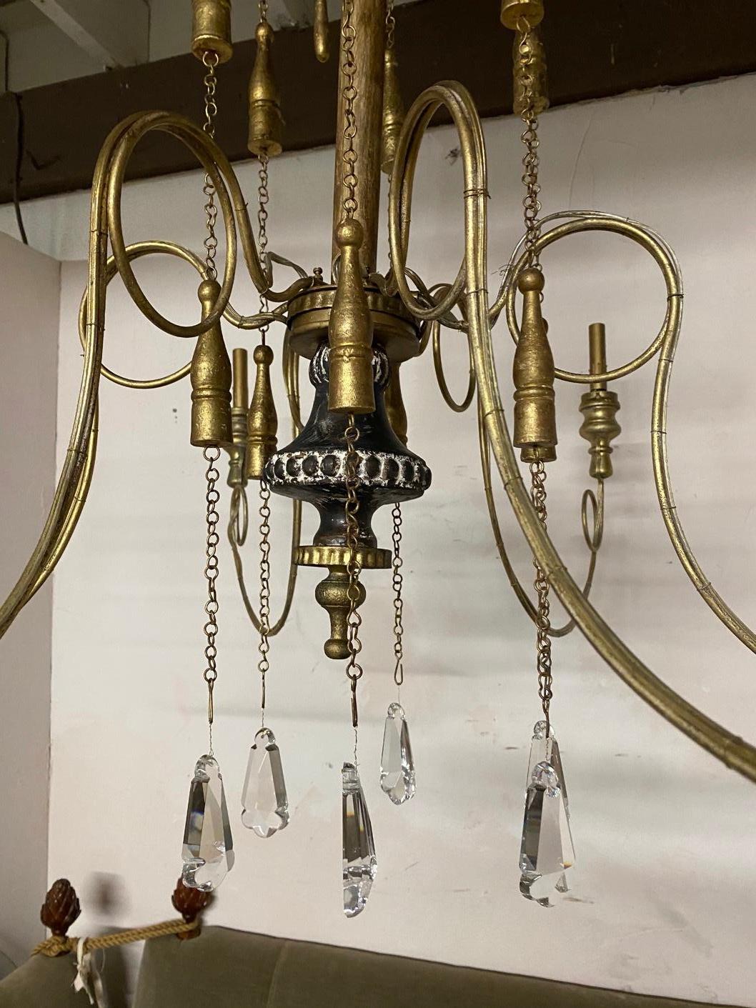 Large, elegant and impressive, newly restored antique Swedish Gustavian style chandelier with 6 scrolled arms and gold hanging wood and multifaceted crystal decorations. Elegant curved metal wired arms ending with candle holders wired for electric