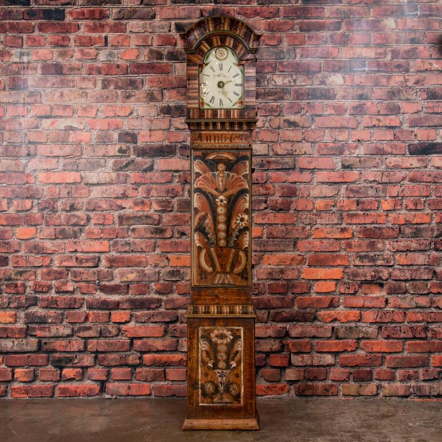 This antique Swedish grandfather clock with original allmoge polychrome paint is dated 1808. This style of Folk Art paint was very traditional in Sweden during the 1800s and utilized mostly earth tones of tan and terra cotta. The signed and dated