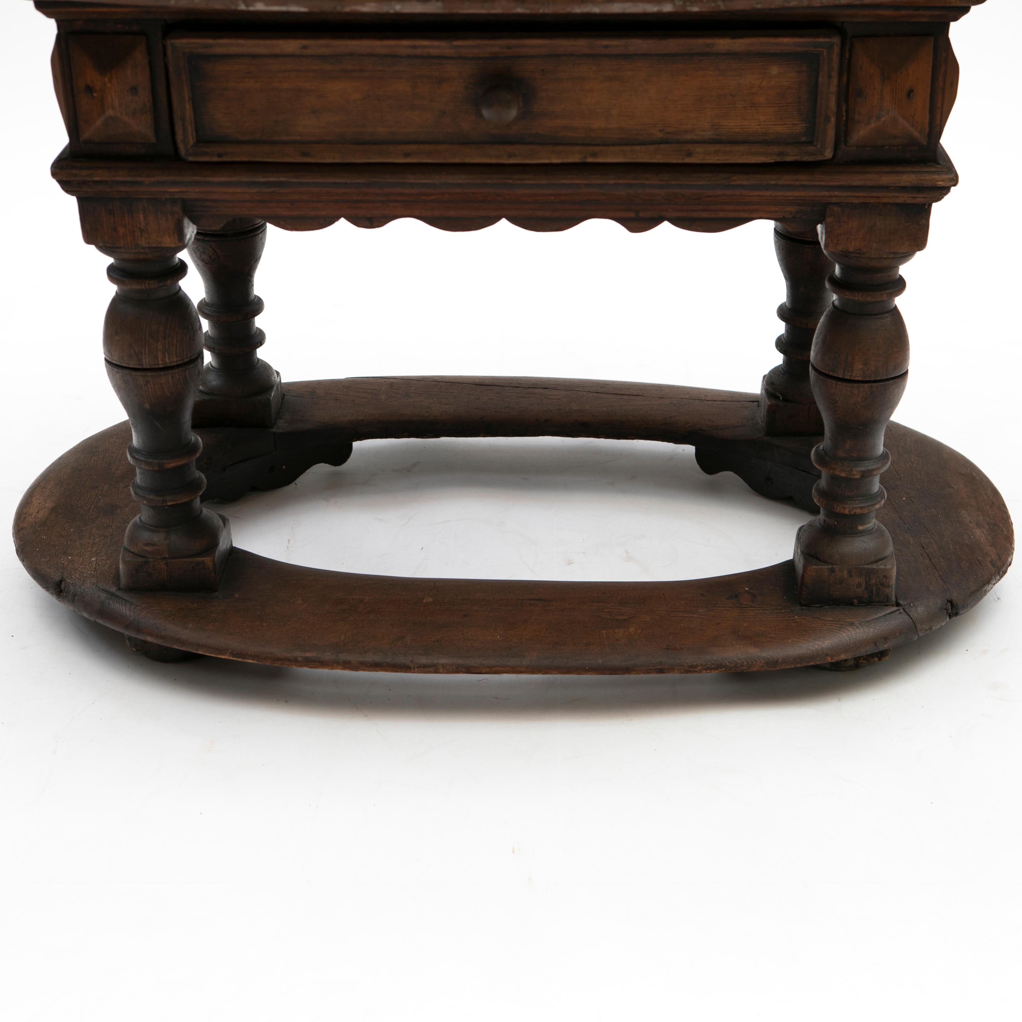 Baroque table in oak and with Öland limestone top.

The oval limestone top contains pre-historic fossils in its surface.
Scalloped skirt with one drawer to the front resting on baluster-shaped baroque legs joined by oval stretcher.

Sweden