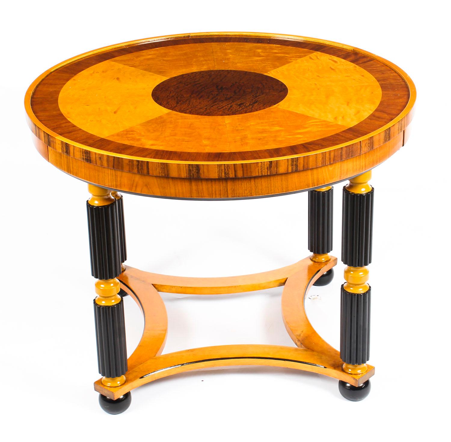 This is a stylish antique Swedish Biedermeier birch coffee table with ebonised detail, circa 1930 in date.
 
The round table features beautifully veneered specimen wood including burr burr walnut, zebra wood, pollard oak and features a pair of