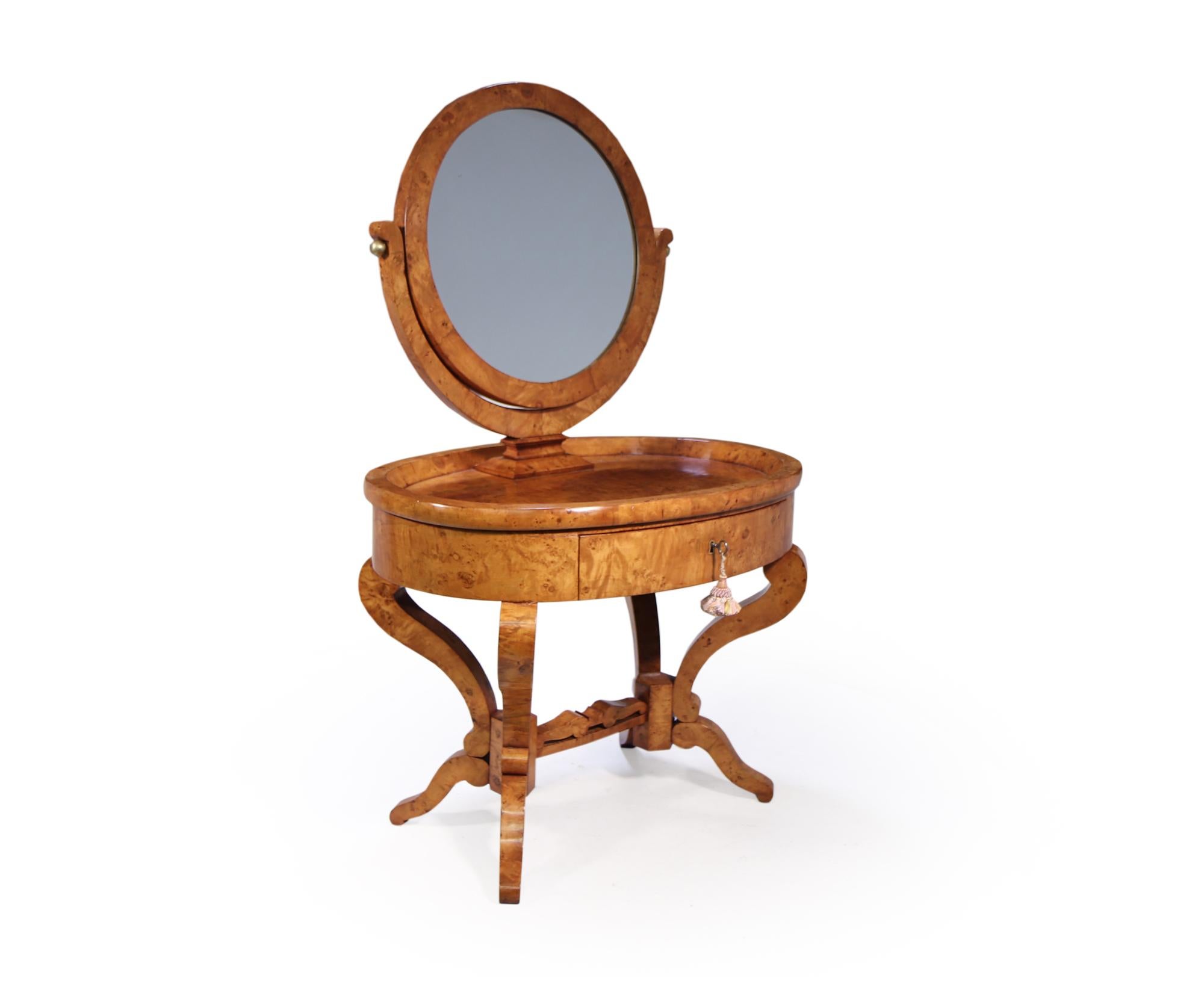 A stunning antique Swedish dressing table with round mirror in satin birch, dating from around 1880. it has a single drawer and tilting mirror this is adjustable with gilt bronze ball tighteners this all stands on a shaped base, the dressing table