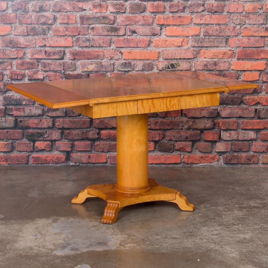 The dramatic birch wood is mesmerizing and draws you to reach out and touch this table. Simple and elegant, this Swedish drop leaf table is made from a rich yellow birch that glows with depth and character. Of special note are the stylized paw feet