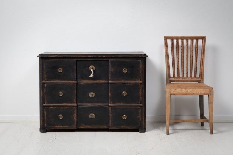Antique Swedish black bureau with three functional drawers. The top drawer has an added detail of built-in interior sections, see picture. The bureau is from around 1850 and is made in painted pine that has patina and distress. The paint is however