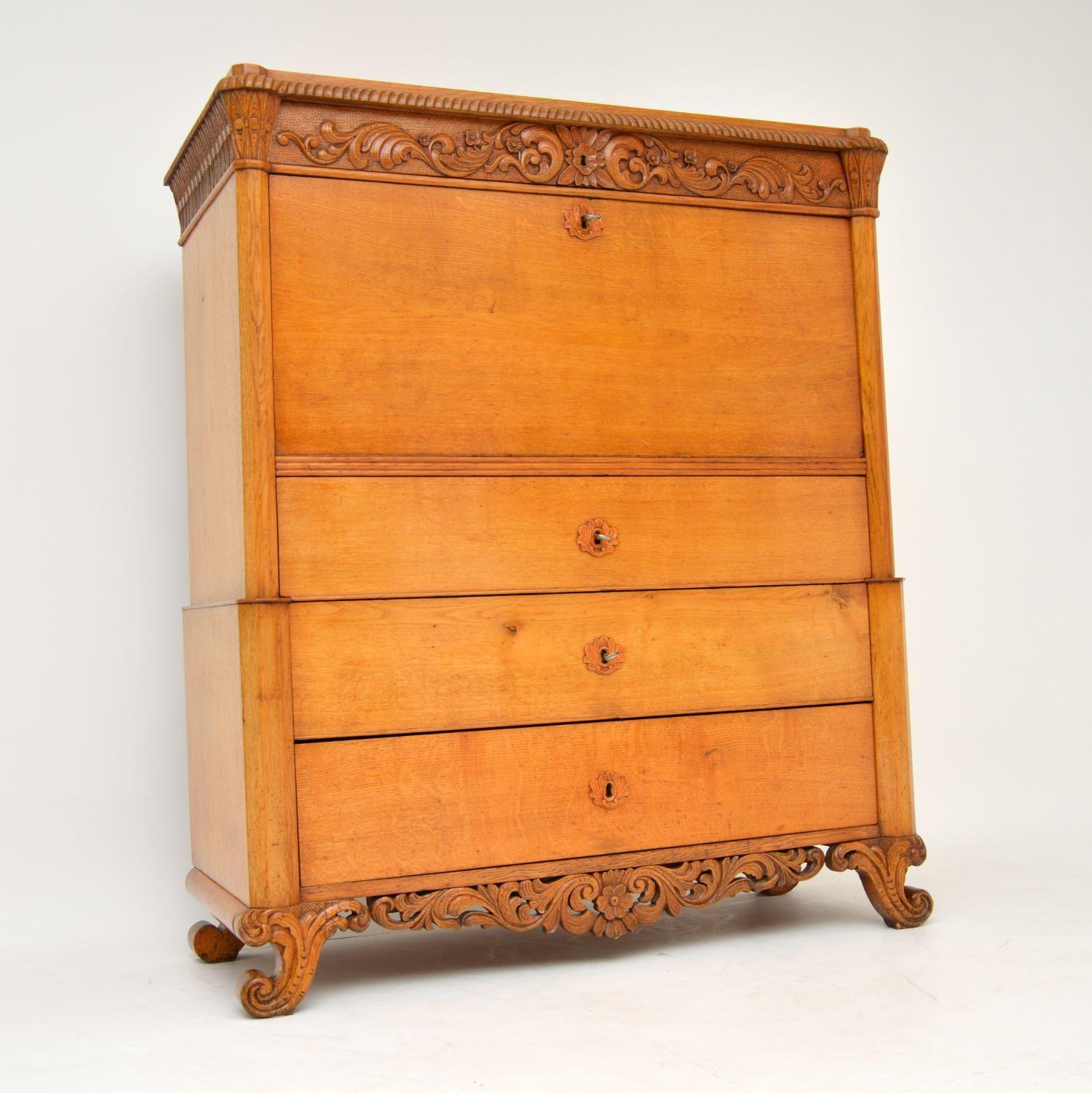 Very impressive antique Swedish secretaire chest dating from around the Gustavian 1860s period and in a lovely golden oak.

It’s beautifully carved all around the top and across the concealed top drawer. The front comes down as a writing surface