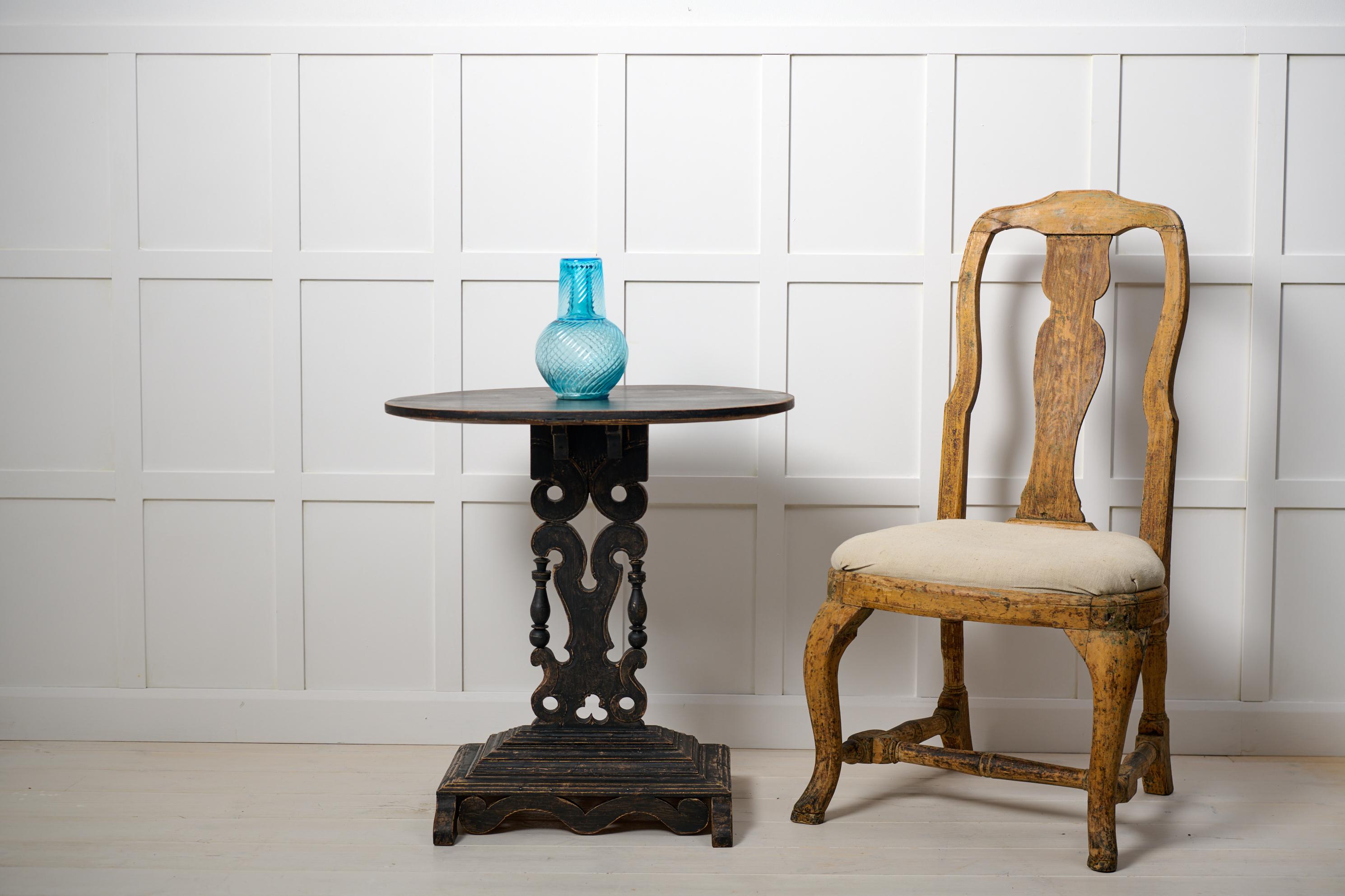 Schwedischer, antiker, verzierter Tisch mit ovaler Tischplatte aus Nordschweden, um 1880. Der Rahmen ist aus massivem Kiefernholz gefertigt und schwarz lackiert. Die Säule und der Sockel sind kunstvoll mit Schnitzereien und abgeschrägten Kanten