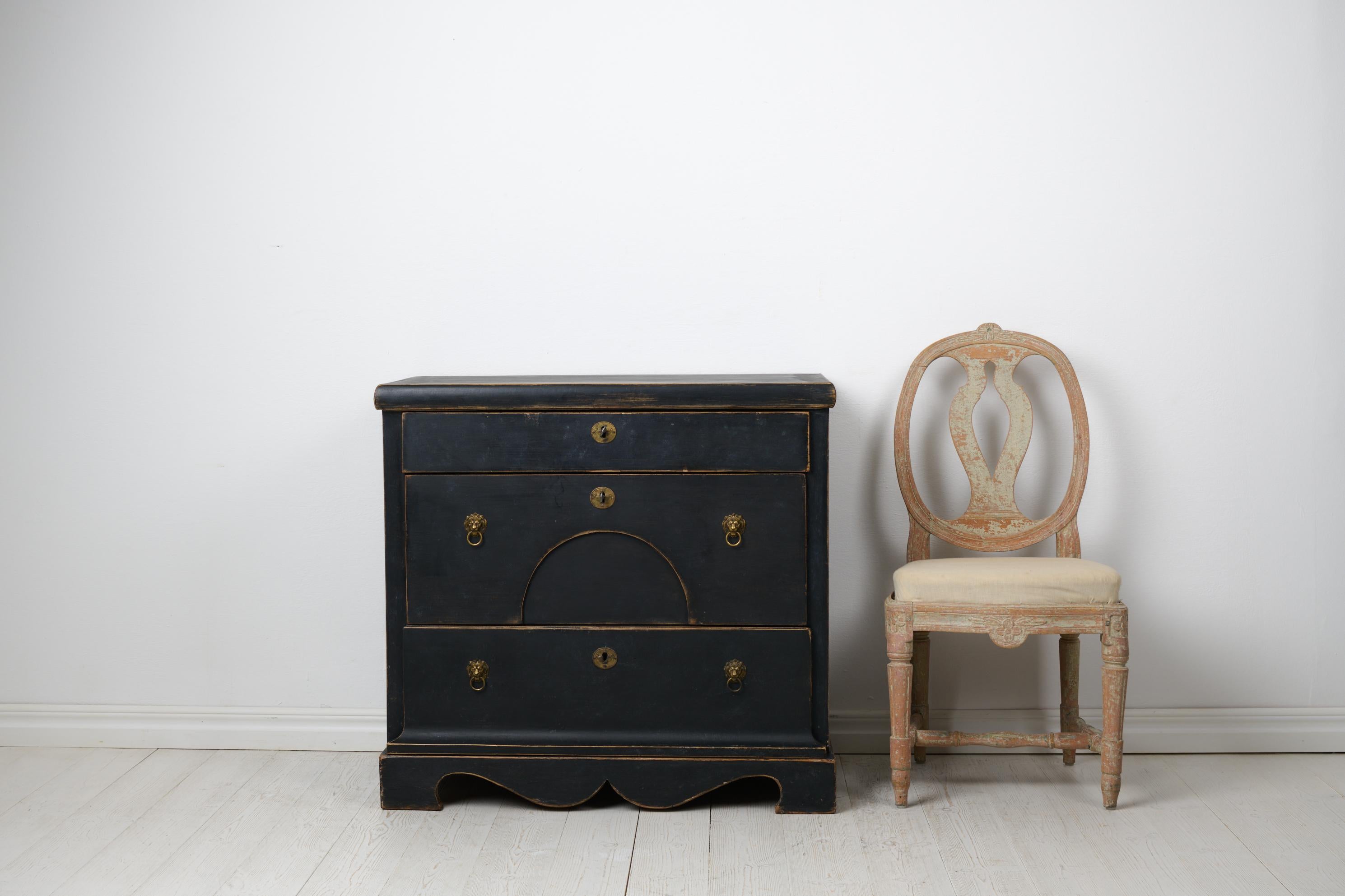 Antique Swedish chest of drawers in empire style from around 1840. The chest is made by hand in solid pine with three large, functional drawers. The hardware is made in brass. The chest still has the locks and the keys are present. The chest itself