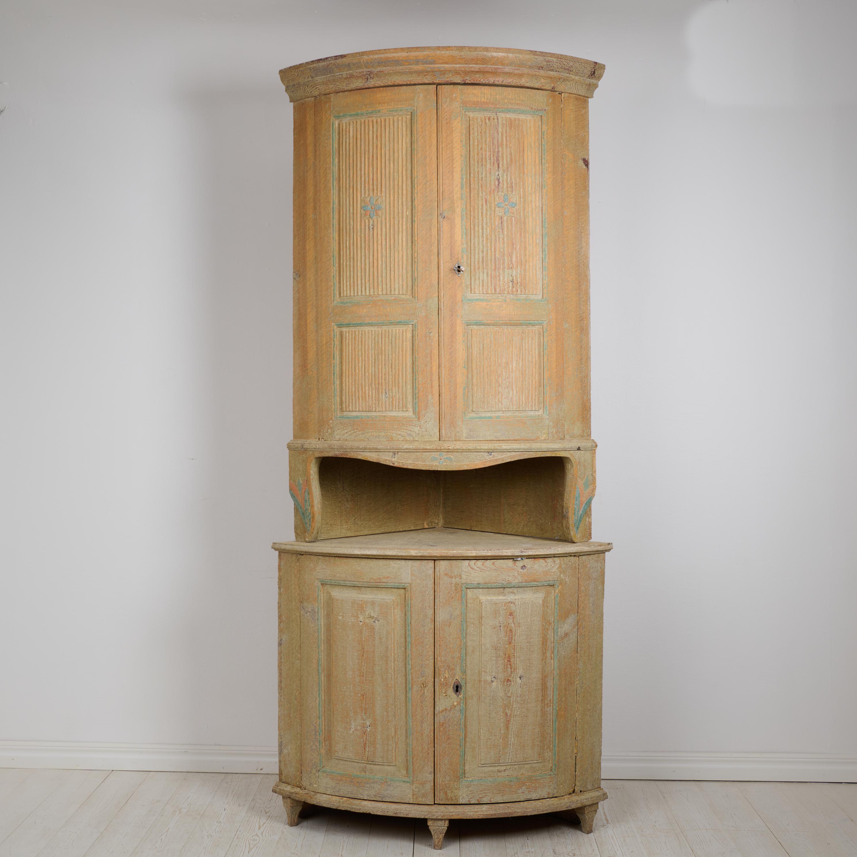 Antique Swedish corner cabinet in gustavian style. The cabinet is in two parts and likely made by master carpenter Jonas Lust (1794-1845) in Forsa, Hälsingland during the early 1800s. Rounded shape with classic gustavian fluted doors. The upper