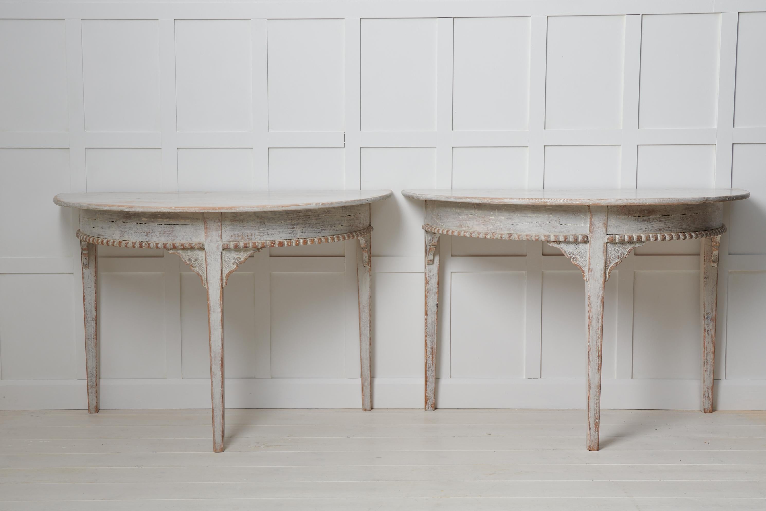Antique demi lune table in gustavian style from Sweden. The table is a country furniture from around the 1840s and is made in two halves. Made by hand in painted pine with an unusual decor with corbels and a carved band wrapping around the table.