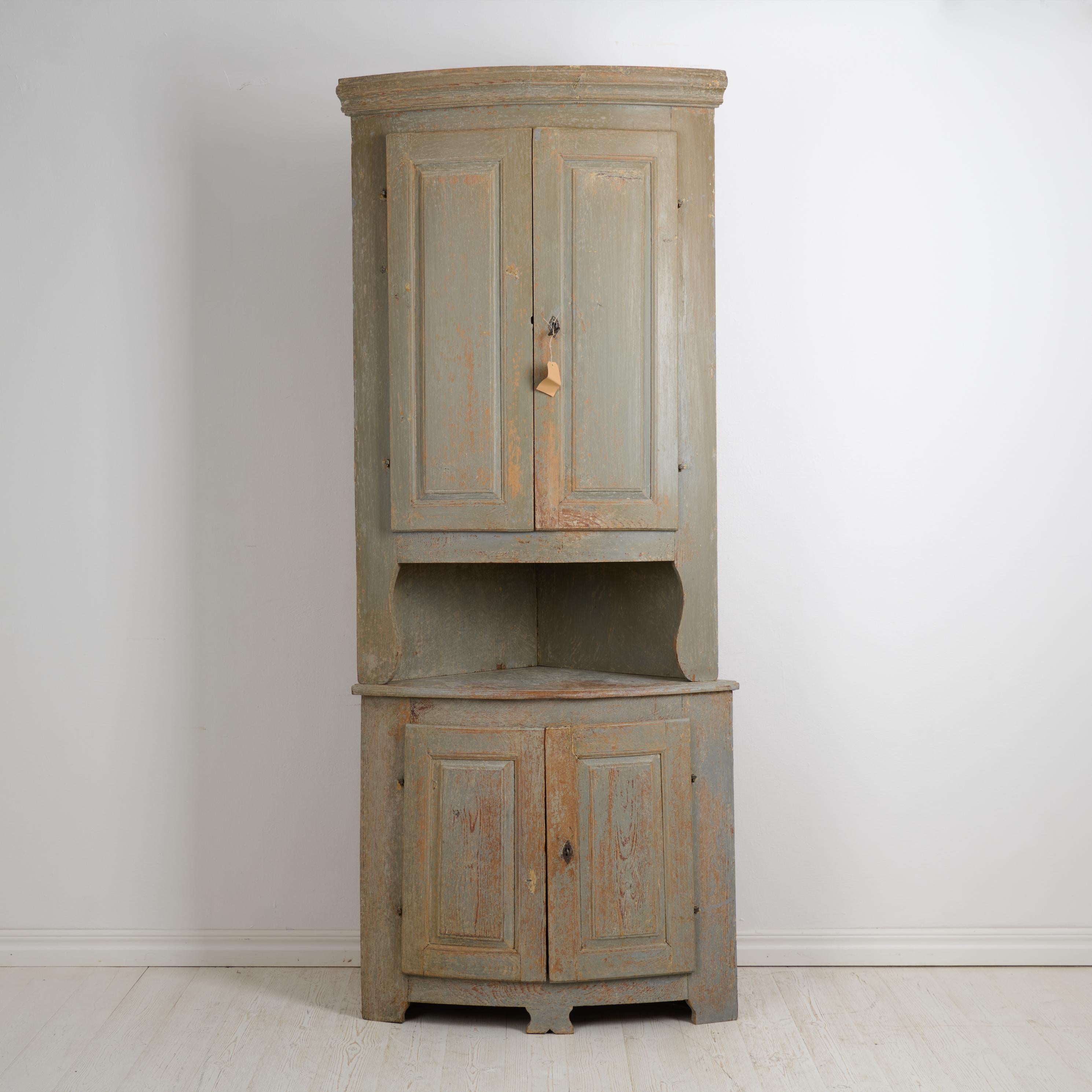 Ancien meuble d'angle suédois du début des années 1800, vers 1820. L'armoire est un meuble de maison de campagne fabriqué dans le style gustavien. Deux parties avec une façade arrondie, des portes doubles et les serrures et clés d'origine qui sont