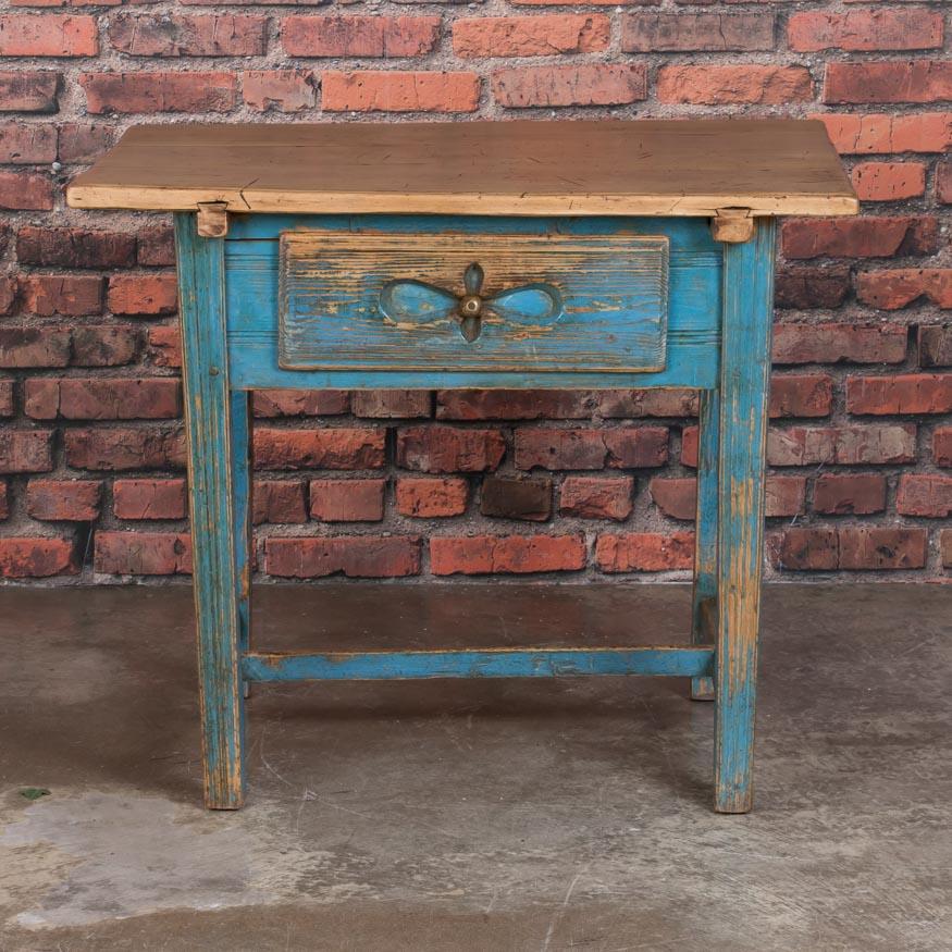The charm of this cottage style table is in the simple details and rich patina of the distressed hard wood top and painted base. On the base, the warm natural pine is exposed where the original blue paint has been lightly worn from years of use,
