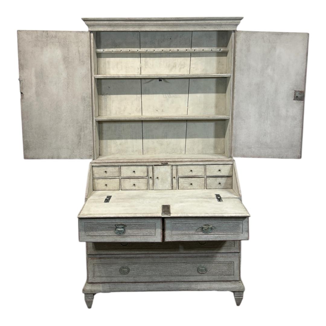 Ein stattlicher und gut erhaltener schwedischer Sekretär aus der Zeit von 1810 bis 1830, gefertigt aus Eiche und Kiefer mit einer sanften grauen Lackierung, die seine eleganten, zurückhaltenden Proportionen unterstreicht. Dieses multifunktionale