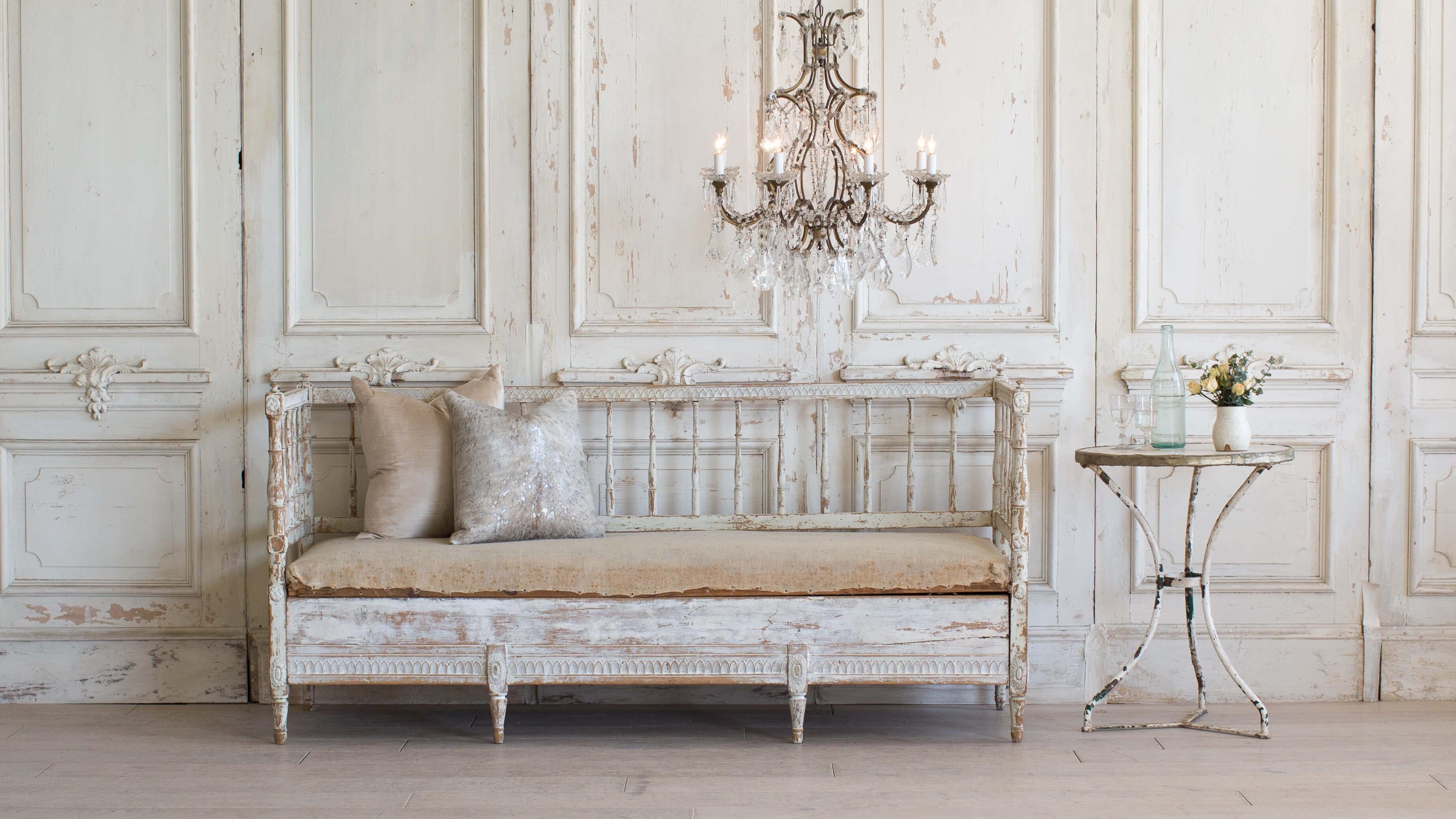 Divine antique Swedish daybed with stunning hand carvings and original muslin seat cushion. Spindle backing and hidden drawer that pulls out for storage or a trundle. Beautiful patina finish with tones of whites and pale green with slight