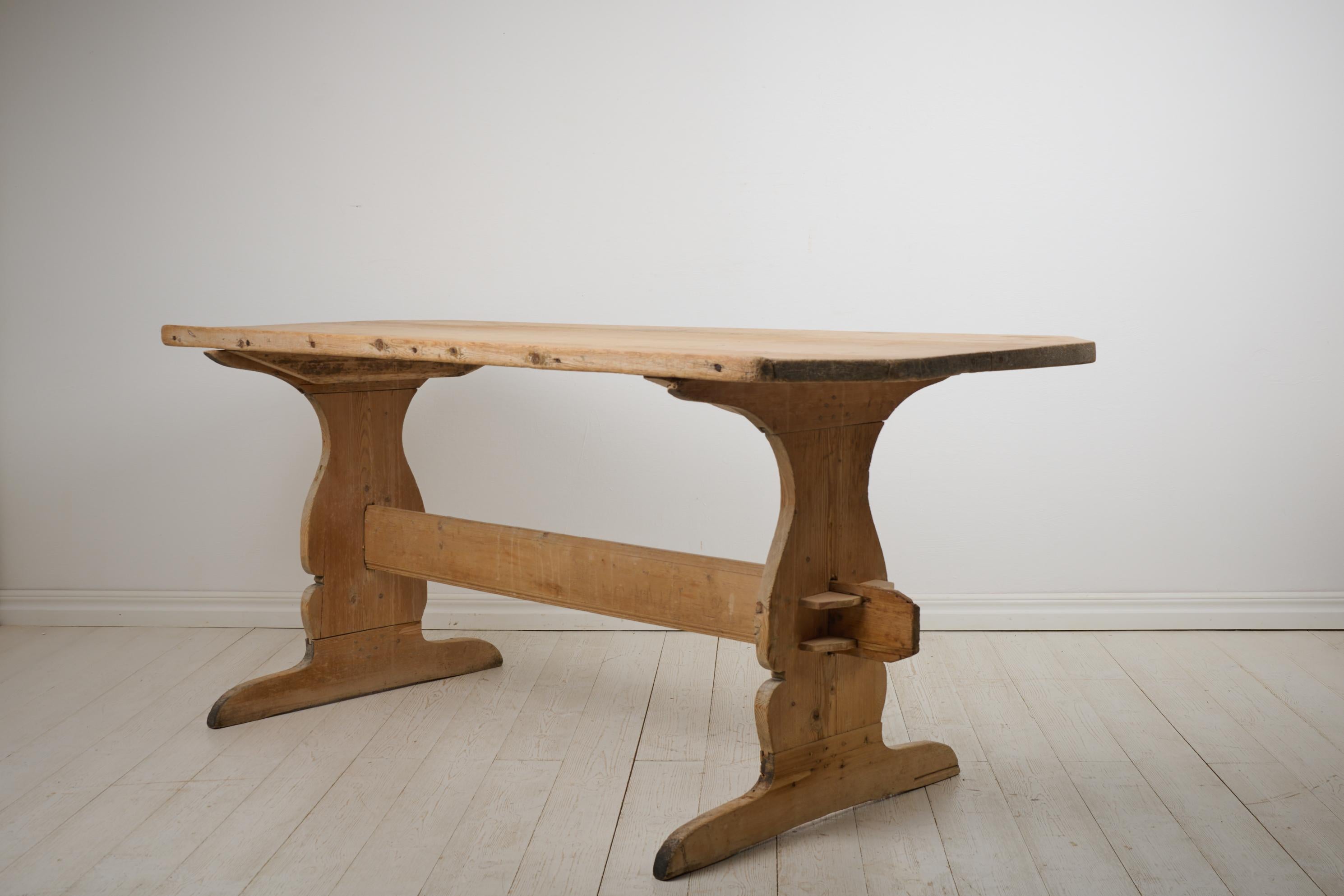 Antique dining trestle table fit for 4-6 people. This folk art, trestle table is from northern Sweden and made around 1830. Made by hand in solid pine and never painted. The table top has an attractive patina with a smooth, light surface after many