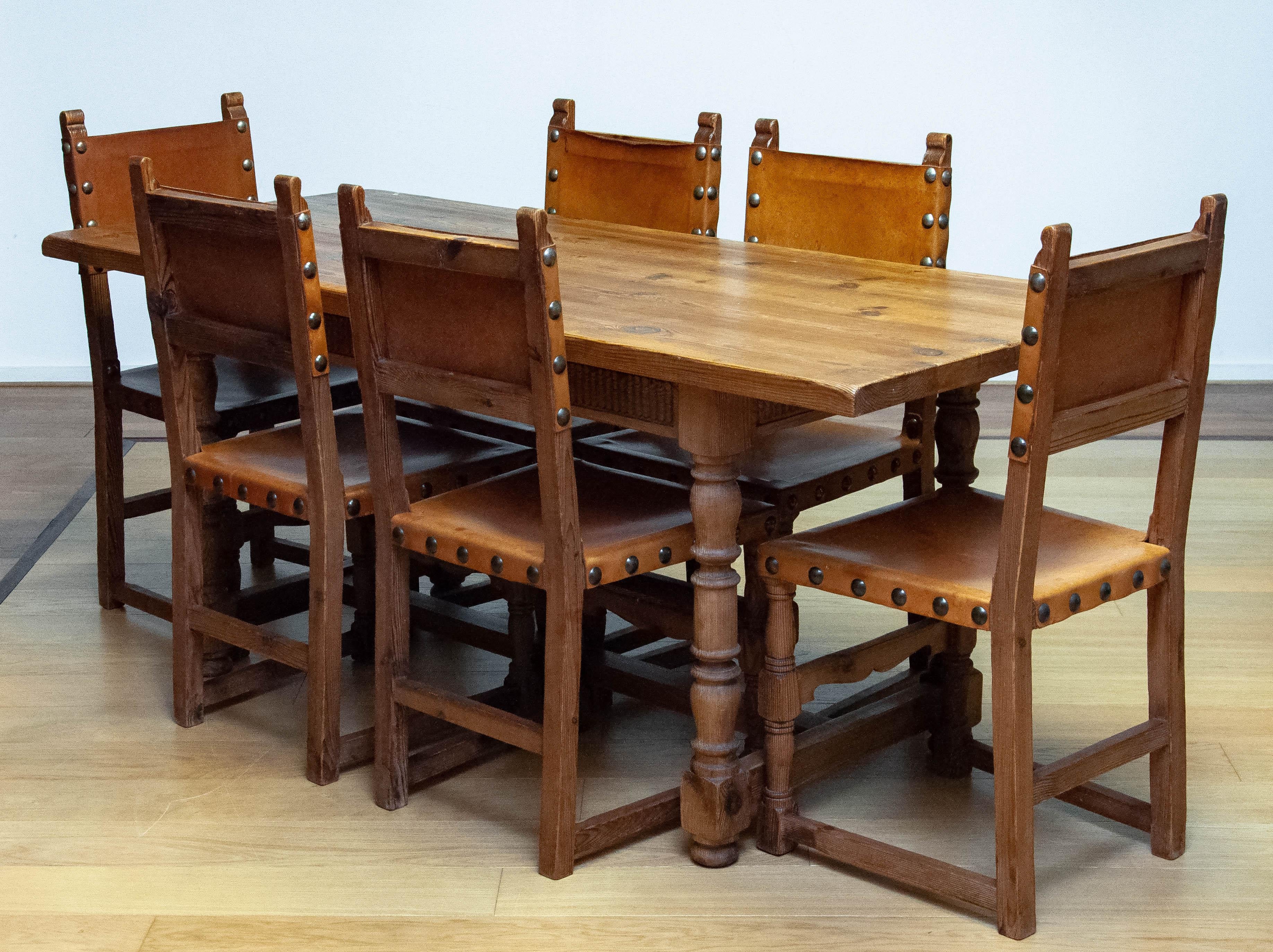 Absolutely beautiful late 19th century Swedish 'Folk Art' country farm dining table in pine with six matching pine dining chairs inline and sturdy tan leather. Because of the dry-out pine grain, true al these years, this set has a fantastic 'lived