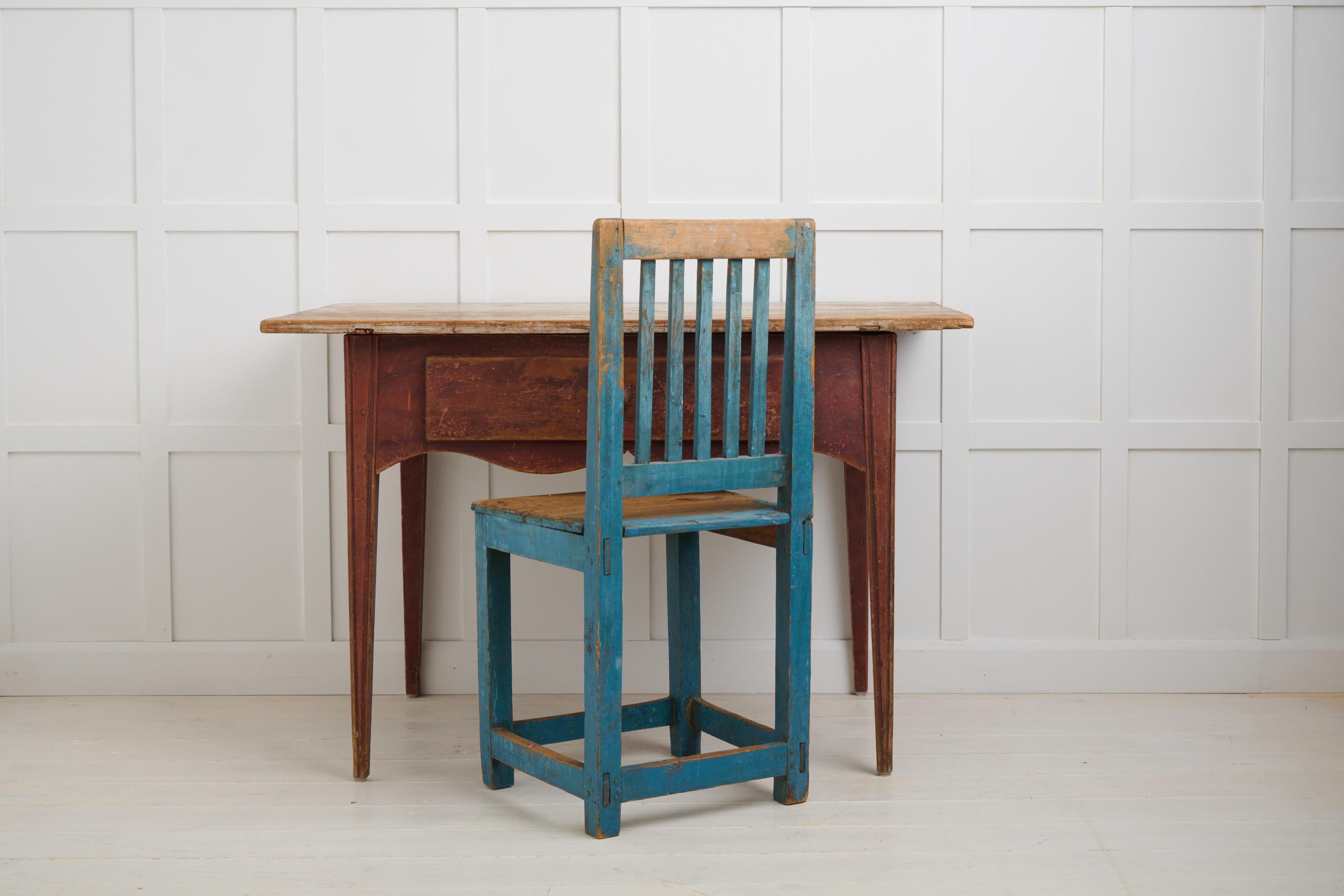 Antique folk art table from Sweden in gustavian style. The table is made by hand in solid pine around 1820 to 1830 in Hälsingland. Gustavian style with straight tapered legs with decorative flutes and a curved apron. The table has a large drawer,