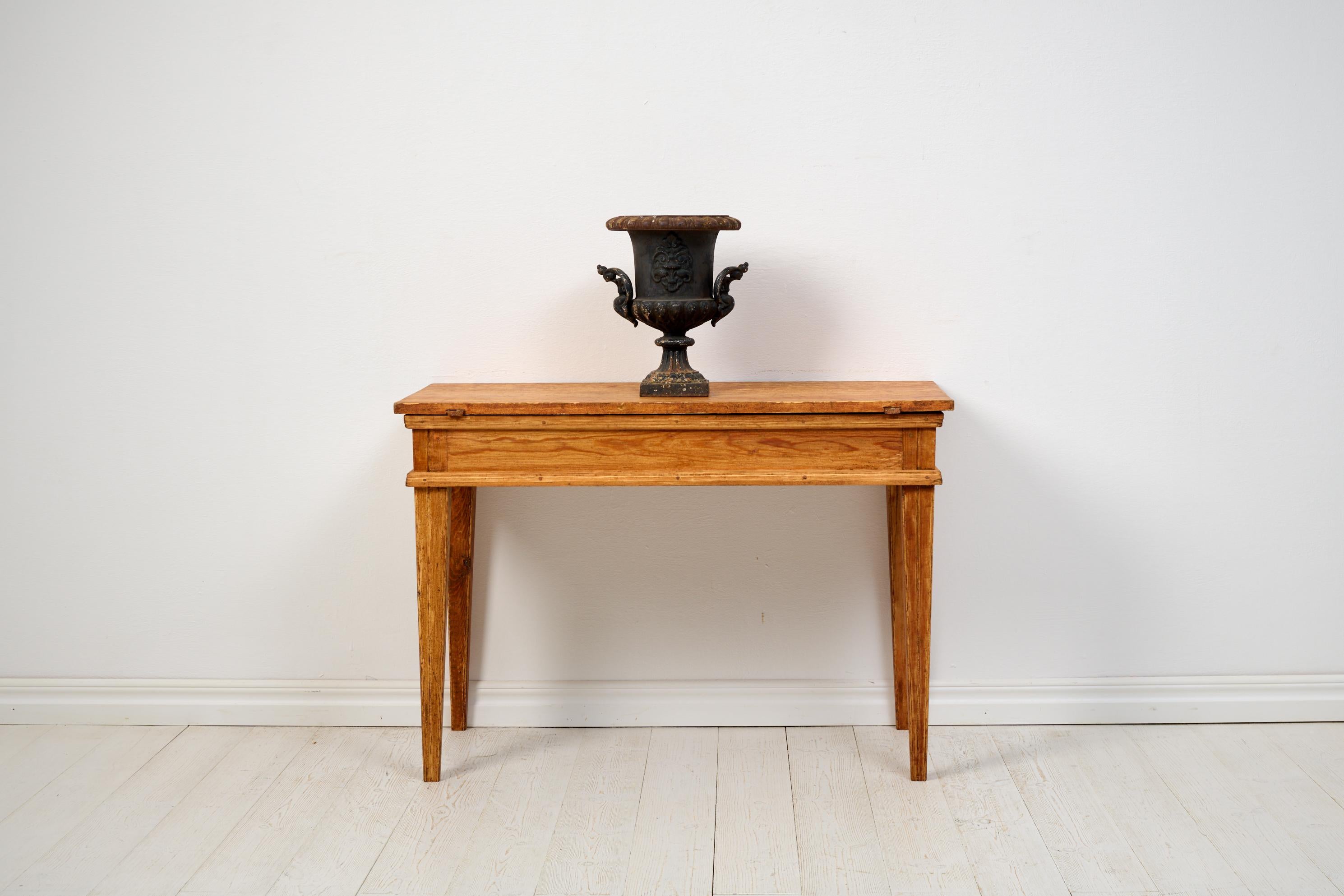 Antique country console table in Gustavian style. All four sides are the same, making it suitable as a freestanding table as well. Handmade in Sweden from solid pine around 1820. The surface is significantly distressed and worn, with almost all the