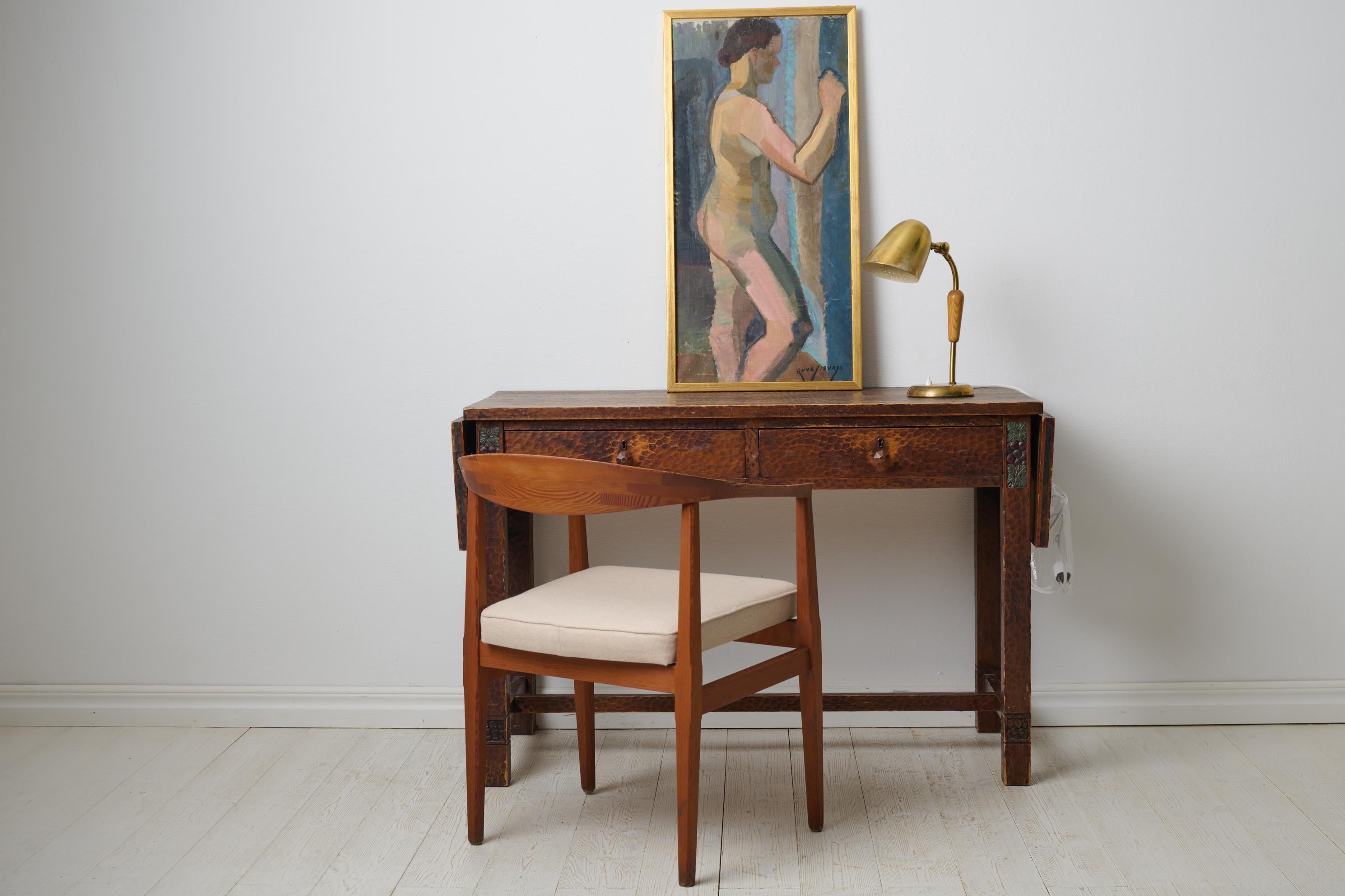 Ancien bureau suédois Grace d'Otto Wretling fabriqué dans le nord de la Suède vers 1915. Le bureau a un cadre en pin avec un décor sculpté à la main qui rend la surface animée et unique. Deux tiroirs extensibles. Les plateaux de table à feuilles