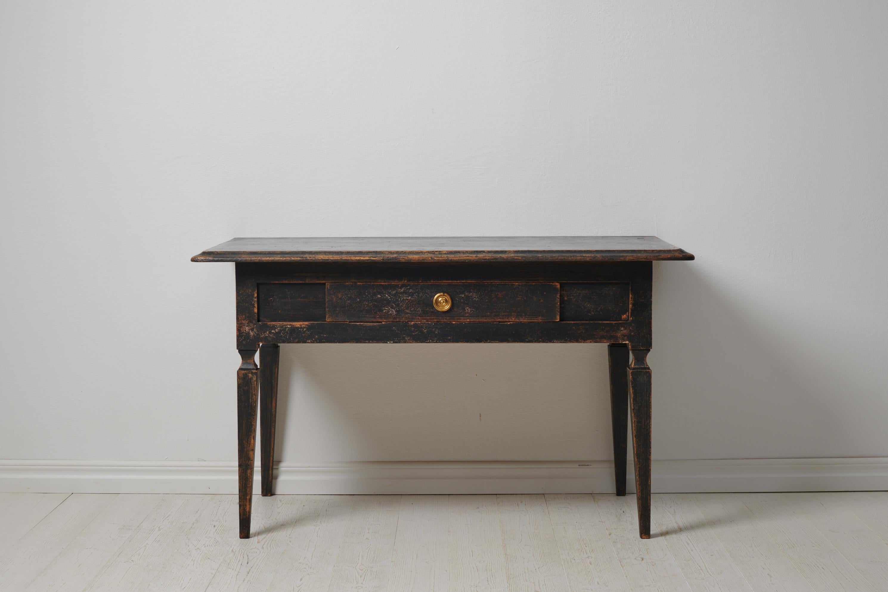 Antique Swedish gustavian table. The table is a genuine country house furniture from the 1820s. Straight tapered legs and a drawer in the apron. The apron is decorated with rectangular panels. The paint has distress with patina and the pine