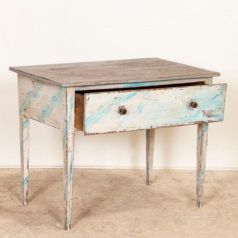 This delightful country Gustavian table with it's low stature would make a great side table or nightstand. The table has an off white/light blue painted finish with blue vein accent, which has been gently distressed and worn bring out years of