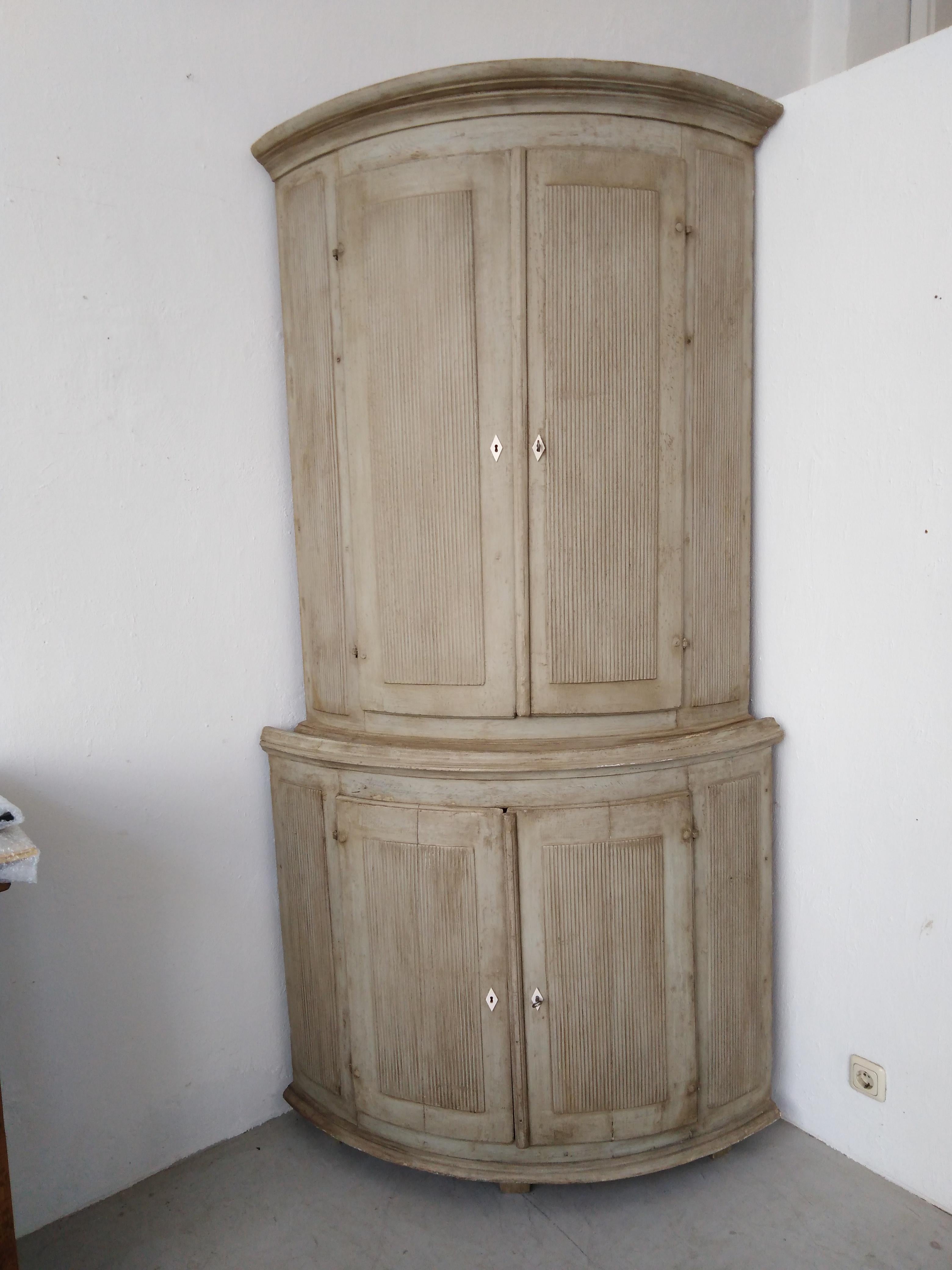 Meuble d'angle en bois peint de style gustavien de la période suédoise, vers 1770-1780. Ce meuble d'angle antique suédois de la fin du XVIIIe siècle présente une forme incurvée, avec un meuble supérieur en retrait, et repose sur des pieds en forme