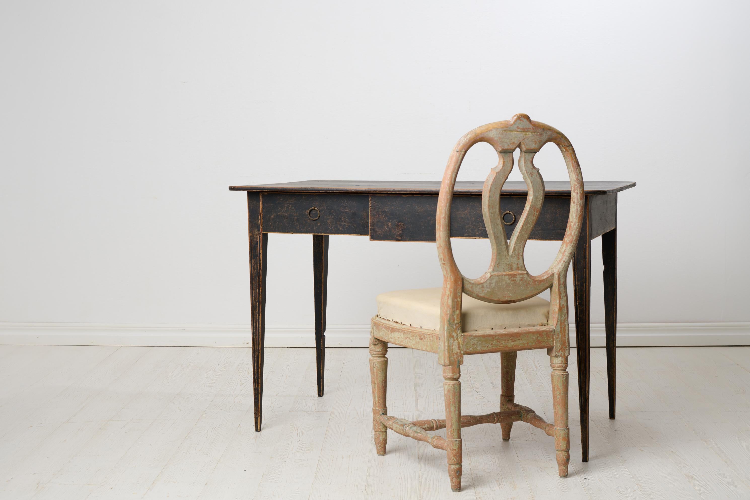 Swedish antique elegant desk from the gustavian period during the late 1700s. Frame in solid pine. The paint has distress and patina. Large drawer. Unusual thin and elegant legs with flutes. Good size and height for seating, see measurements.