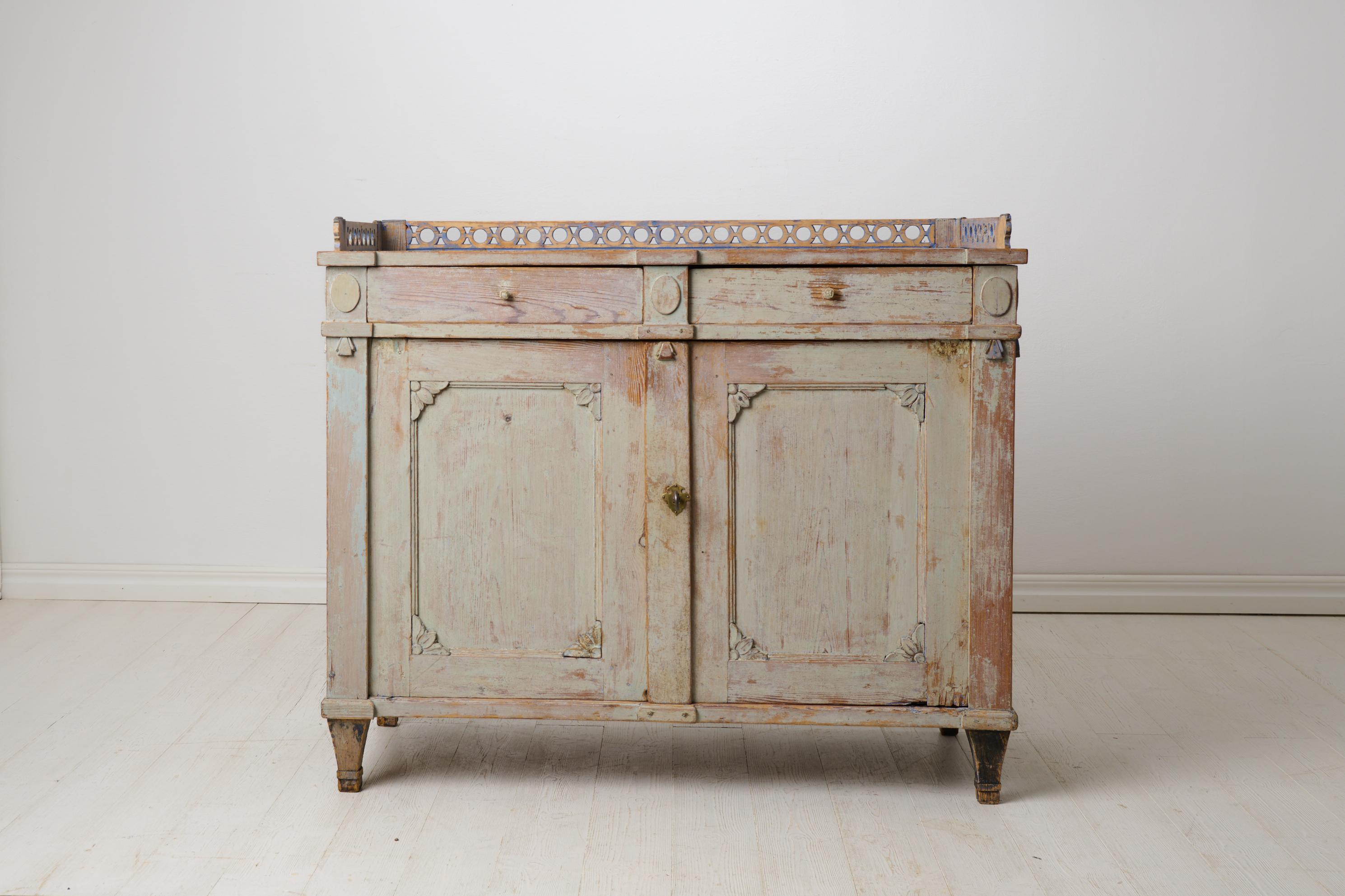 Antique gustavian elegant sideboard from northern Sweden. Straight classic shape. The sideboard is made by hand in solid Swedish pine around 1820 to 1830. Scraped to original paint which has an attractive distress and patina. Hand-carved wooden