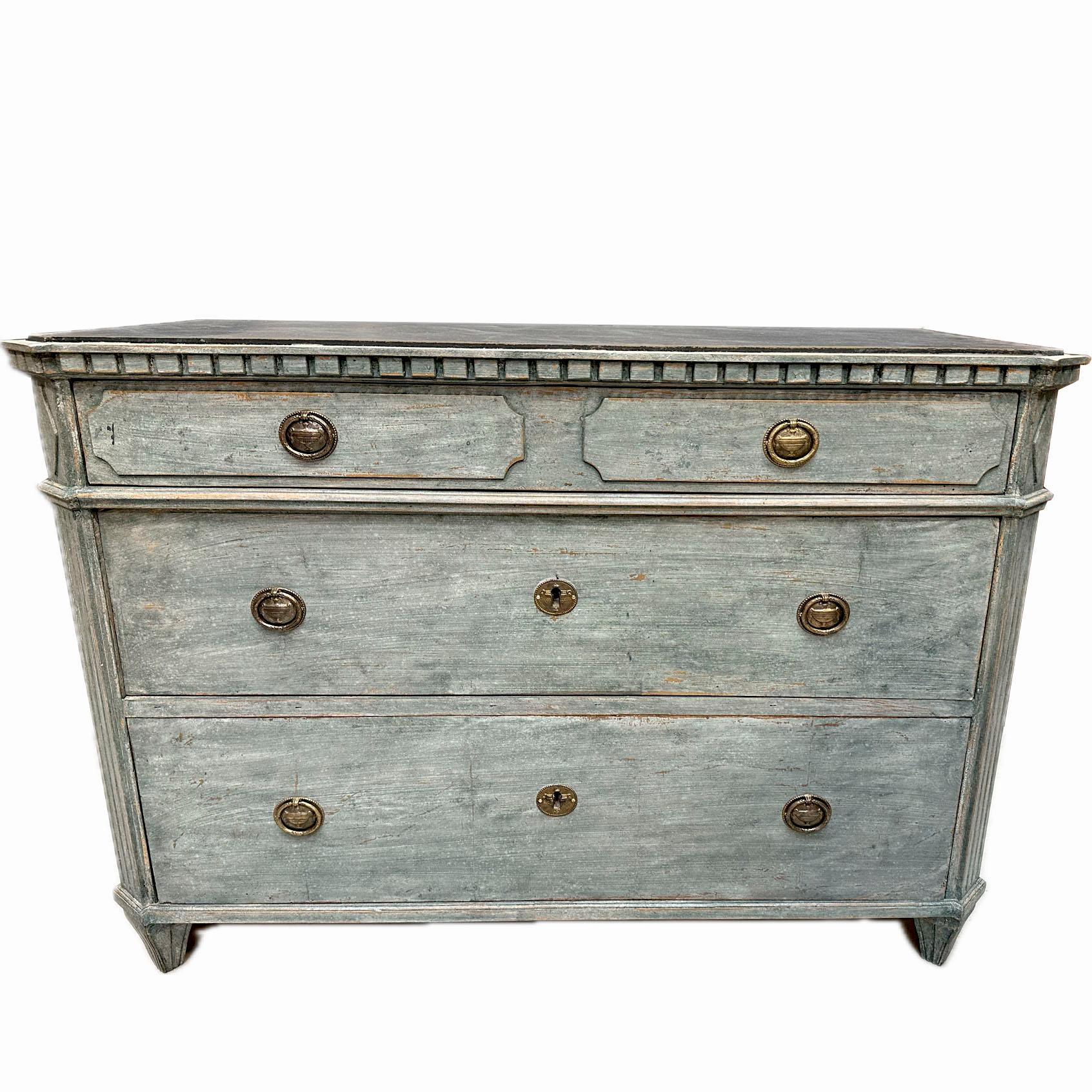 Swedish Gustavian style chest of three drawers, dating from the mid 19th century, painted in a blue color scheme. Later professional painted with a lovely patina.
Features a wooden black faux marbled tabletop with canted corners and dentil mouldings