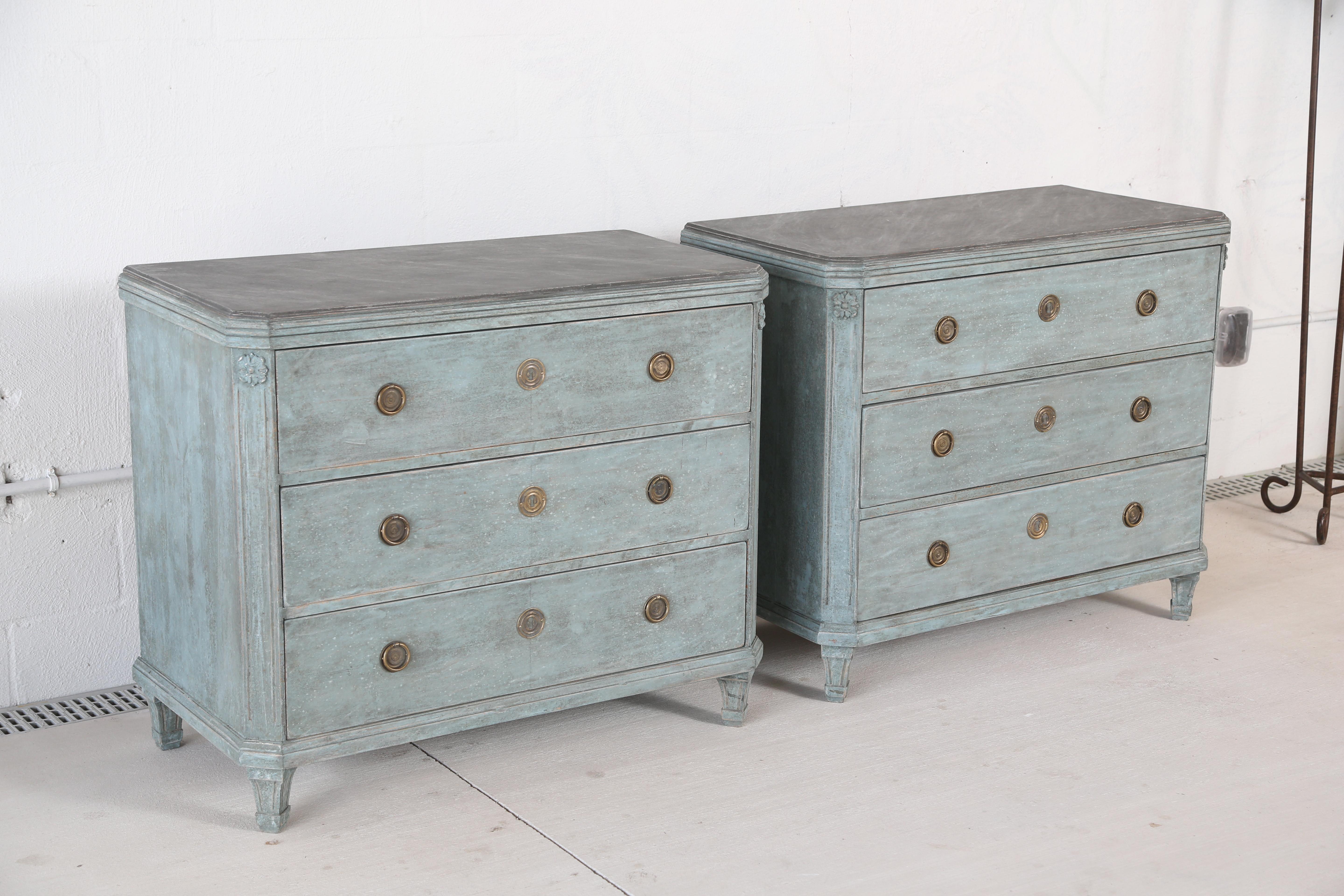 Pair of antique Swedish Gustavian style blue painted chests, each with faux painted marble tops in gray colors, three drawers with Classic Swedish brass hardware, cut corners with a rosette top and fluted,
 ending with tapered fluted legs. Lovely