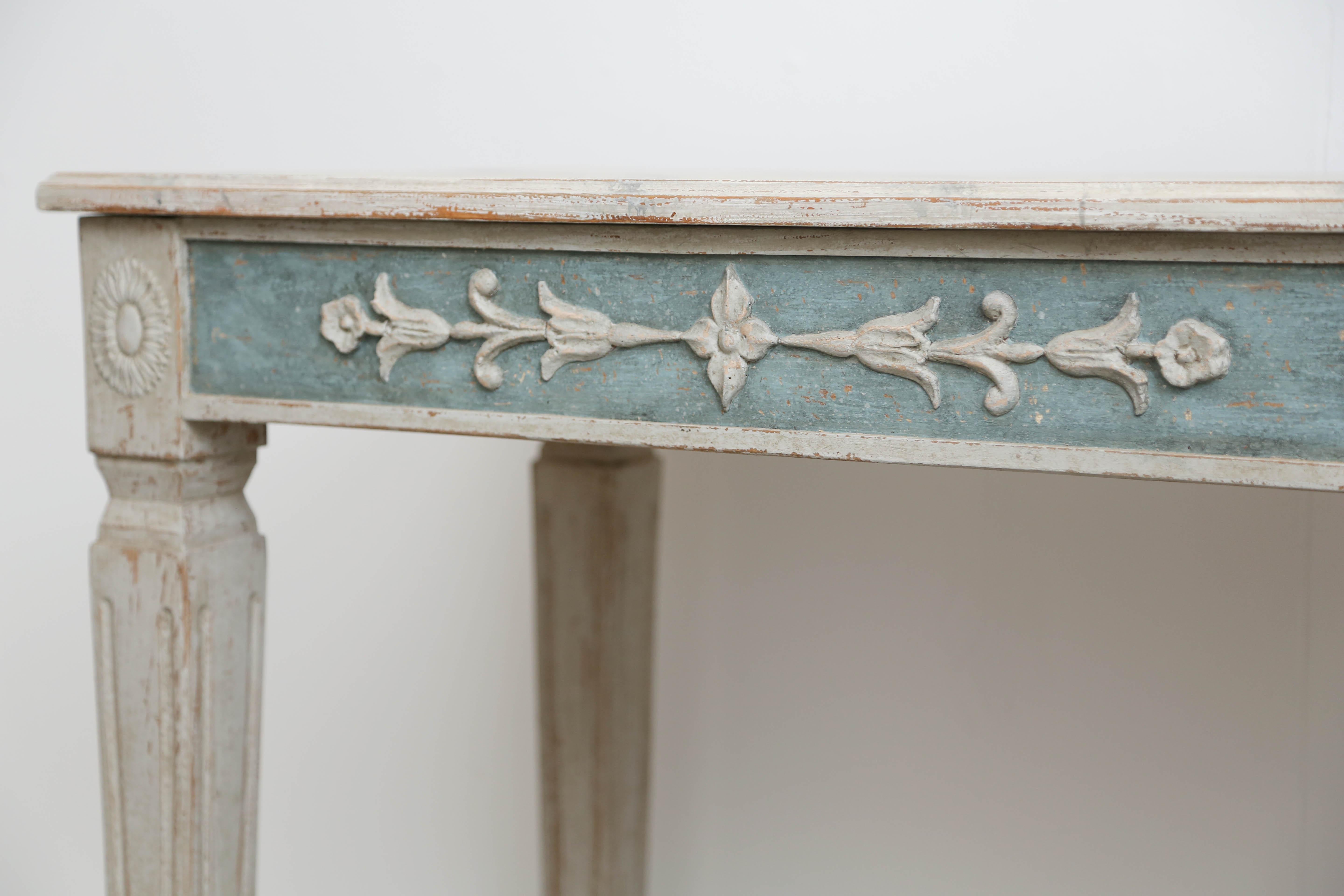 Antique Swedish Gustavian style painted console with faux grey marble top, apron adorned with rosettes and bell flower carvings and painted a lovely Swedish blue background, square tapering fluted legs, console is painted in Swedish grey distressed