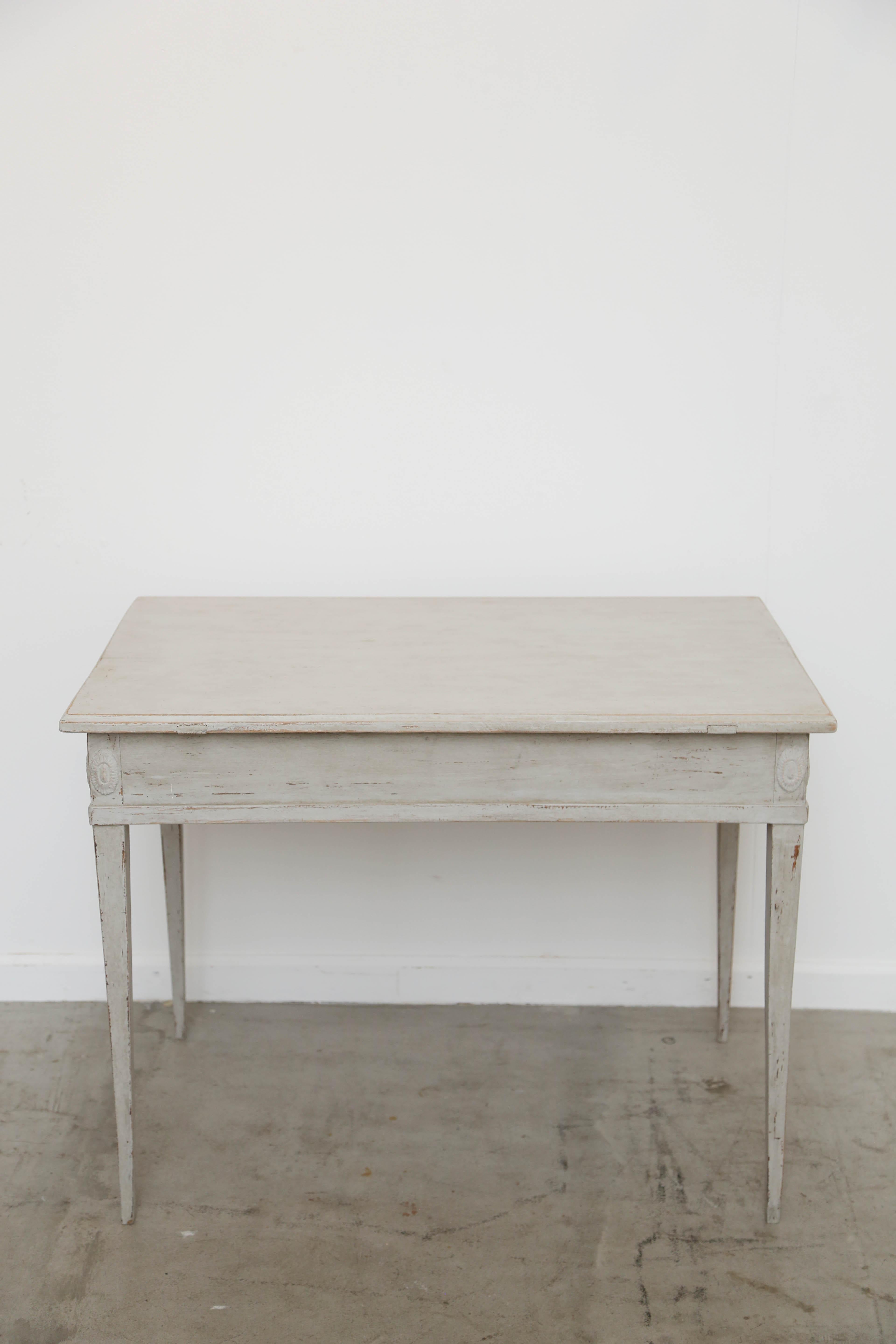 Antique Swedish painted writing desk with three drawers and locks. The desk is on tapered legs with carved rosettes at top of each leg in the apron. Painted in Swedish distressed pale grey/white finish. The desk is priced separately from the letter