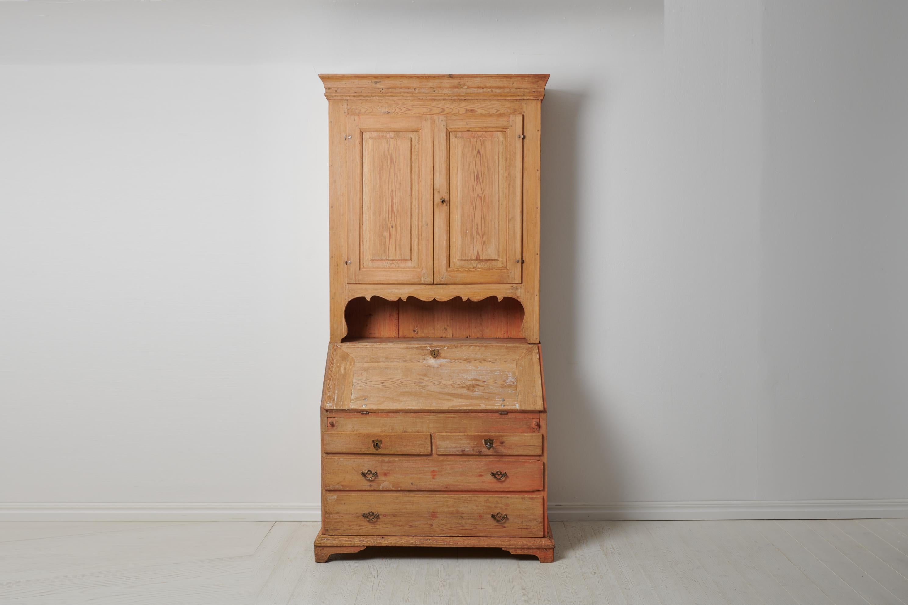 Antique Swedish secretary cabinet in gustavian style. The cabinet is made in northern Sweden around the 1820s. The cabinet is a well crafted piece in two parts made by hand in solid pine. The exterior has significant distress to the paint, the