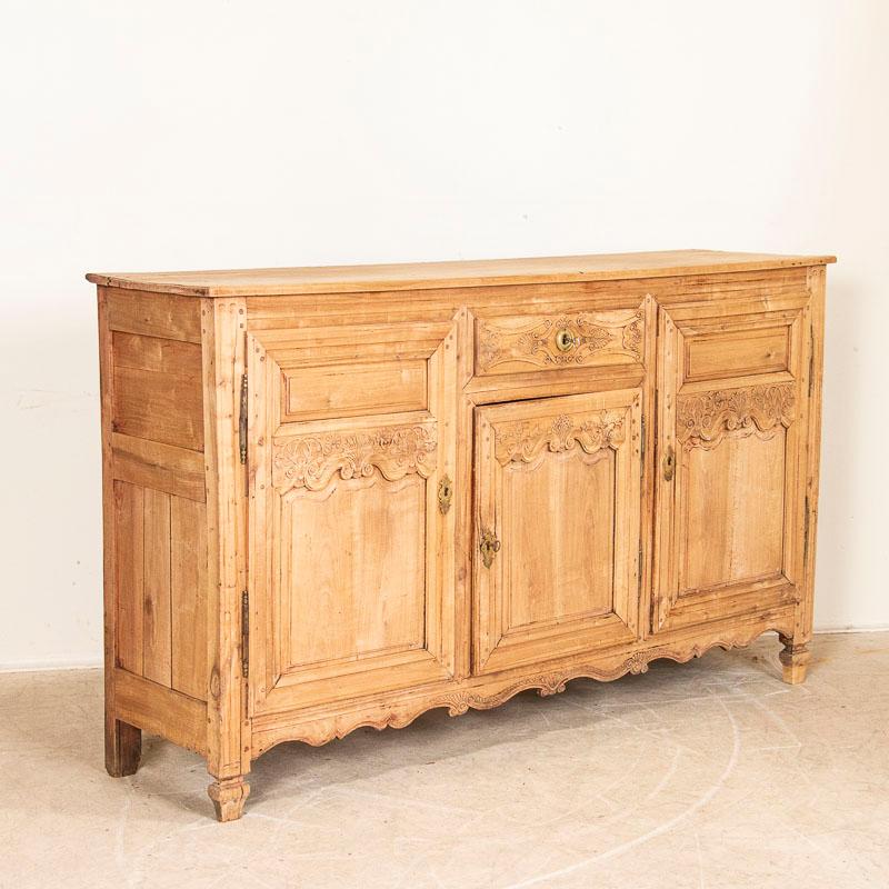 This long sideboard shows off its French style in the carved panels and lovely details along the skirt, door & drawer panels. Note the elaborate carving along the central drawer, top of doors and scalloped skirt. The bleached finish gives it a fresh